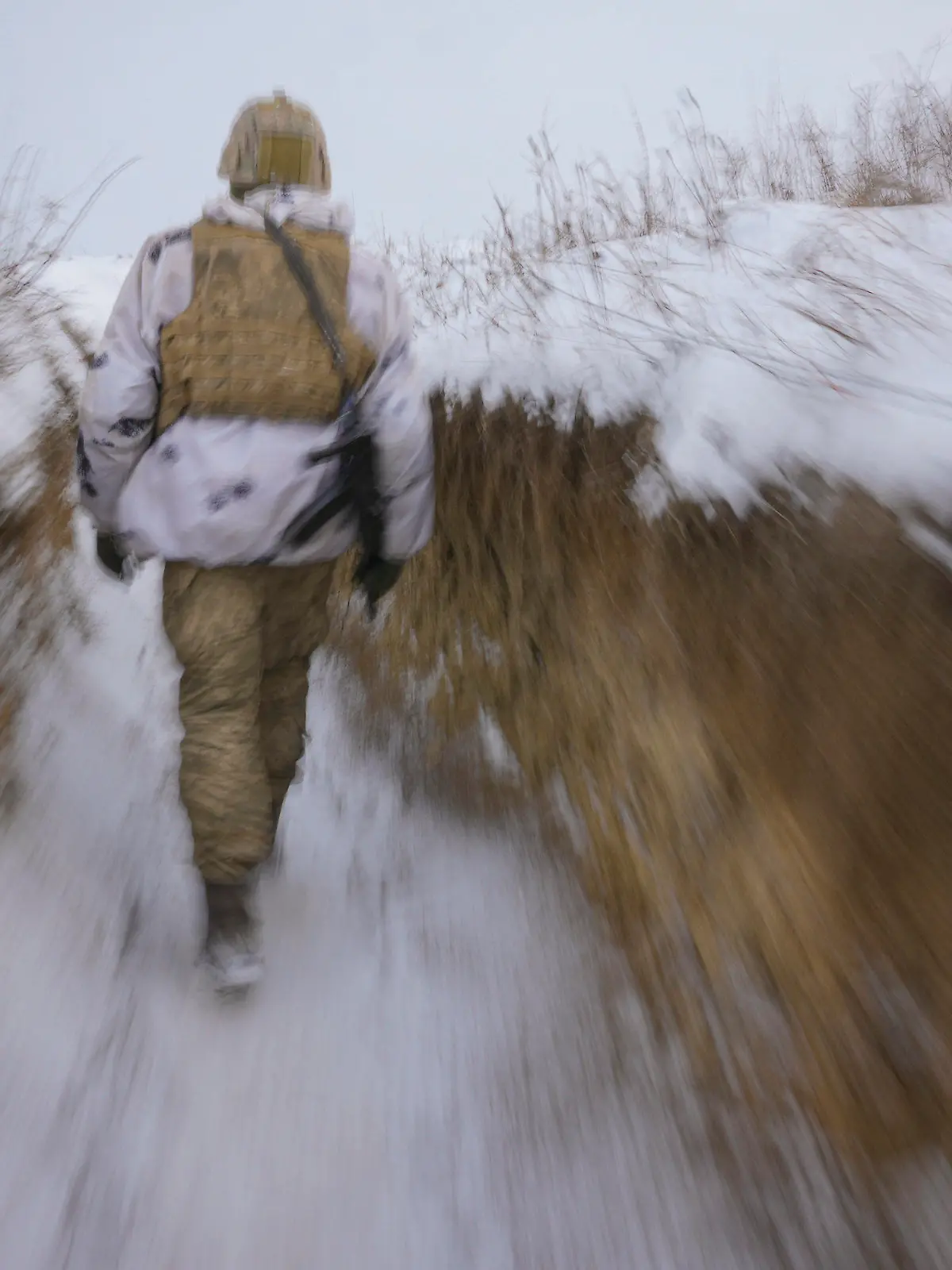 dpatopbilder - 27.01.2022, Ukraine, Luhansk: Ein ukrainischer Soldat geht an der Frontlinie durch einen Graben. Bei den massiven Spannungen zwischen Russland und dem Westen im Konflikt um die Ukraine ist auch nach den schriftlichen Antworten der USA und der Nato kein Ende in Sicht. Der Kreml ließ den Westen zunächst im Unklaren darüber, wie Russland im Ringen um Sicherheitsgarantien auf das Dialogangebot reagiert. Foto: Vadim Ghirda/AP/dpa +++ dpa-Bildfunk +++