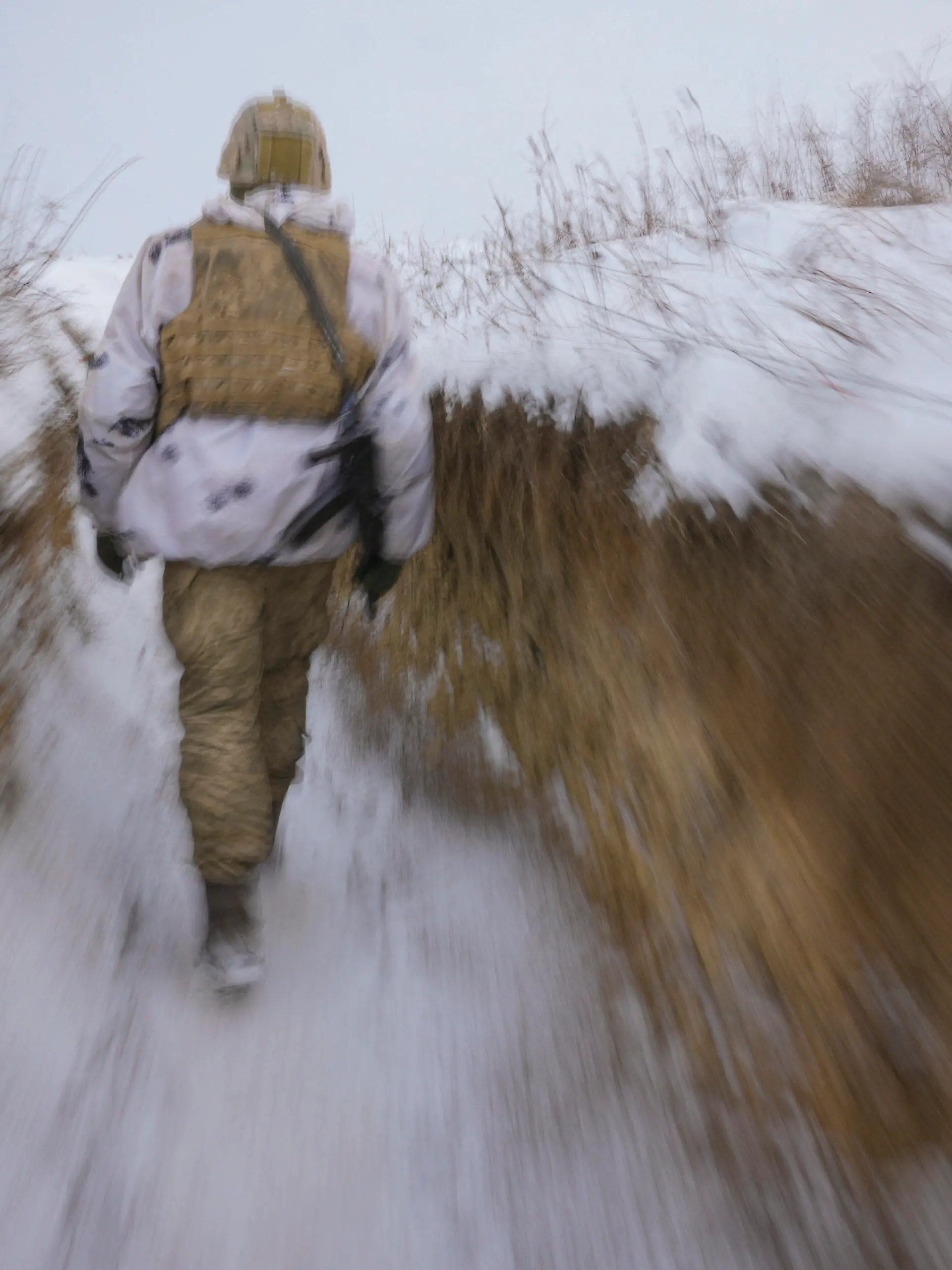 dpatopbilder - 27.01.2022, Ukraine, Luhansk: Ein ukrainischer Soldat geht an der Frontlinie durch einen Graben. Bei den massiven Spannungen zwischen Russland und dem Westen im Konflikt um die Ukraine ist auch nach den schriftlichen Antworten der USA und der Nato kein Ende in Sicht. Der Kreml ließ den Westen zunächst im Unklaren darüber, wie Russland im Ringen um Sicherheitsgarantien auf das Dialogangebot reagiert. Foto: Vadim Ghirda/AP/dpa +++ dpa-Bildfunk +++
