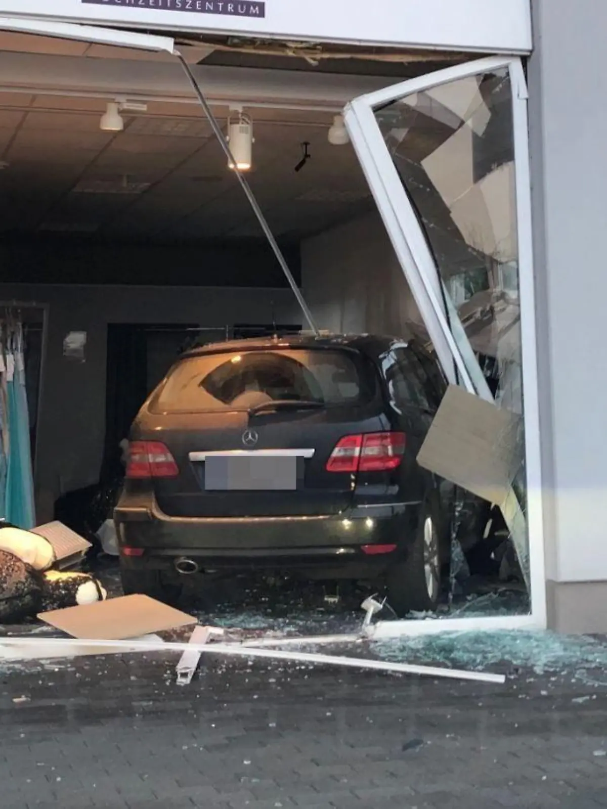 HANDOUT - 27.01.2022, Kerpen: Nach einem missglückten Einparkmanöver ist ein Auto in Kerpen erst im Verkaufsraum eines Brautmodengeschäfts zum Stehen gekommen. Verletzt wurde niemand. (Zu dpa: «Eingeparkt im Brautmodengeschäft») Foto: Polizei Hürth/Polizei/dpa - ACHTUNG: Nur zur redaktionellen Verwendung im Zusammenhang mit der aktuellen Berichterstattung und nur mit vollständiger Nennung des vorstehenden Credits. Das Kennzeichen wurde von der Polizei gepixelt. +++ dpa-Bildfunk +++