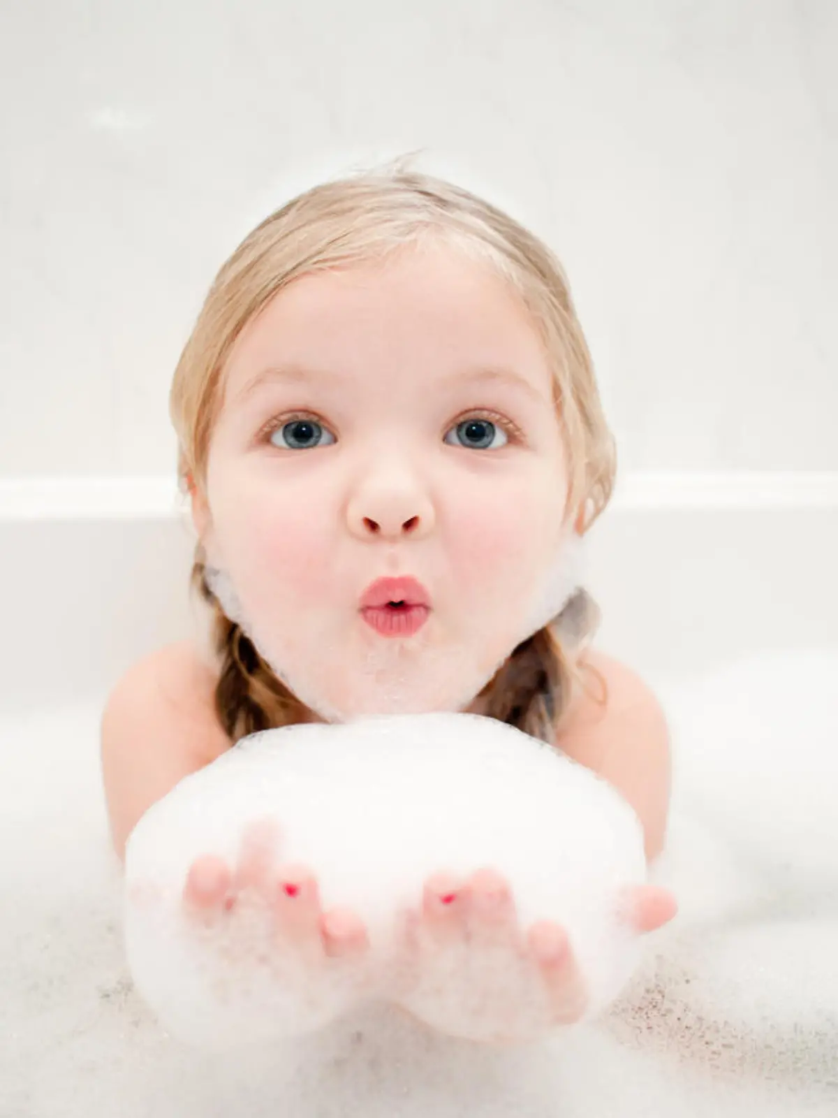 A cute little girl having fun in a bath full of bubbles!