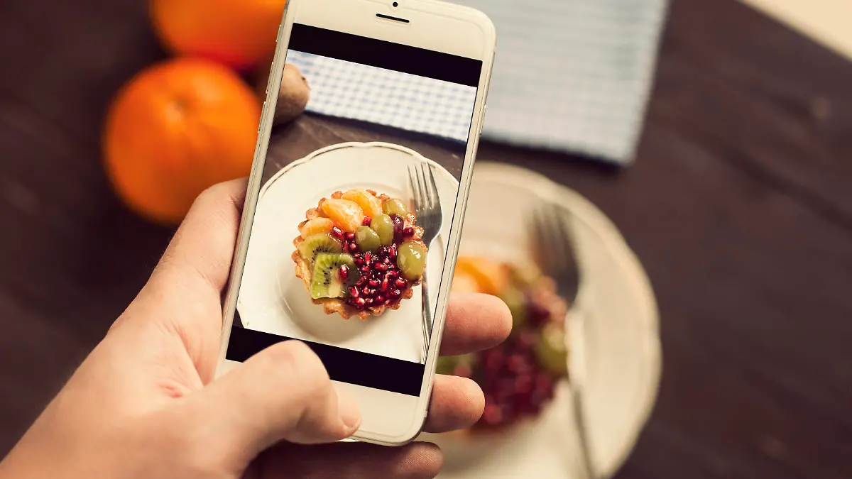 Fruit cake with, kivi, pomegranate, grapes, honey and tangerine. Taking photo of fruit cake. Toned photo
