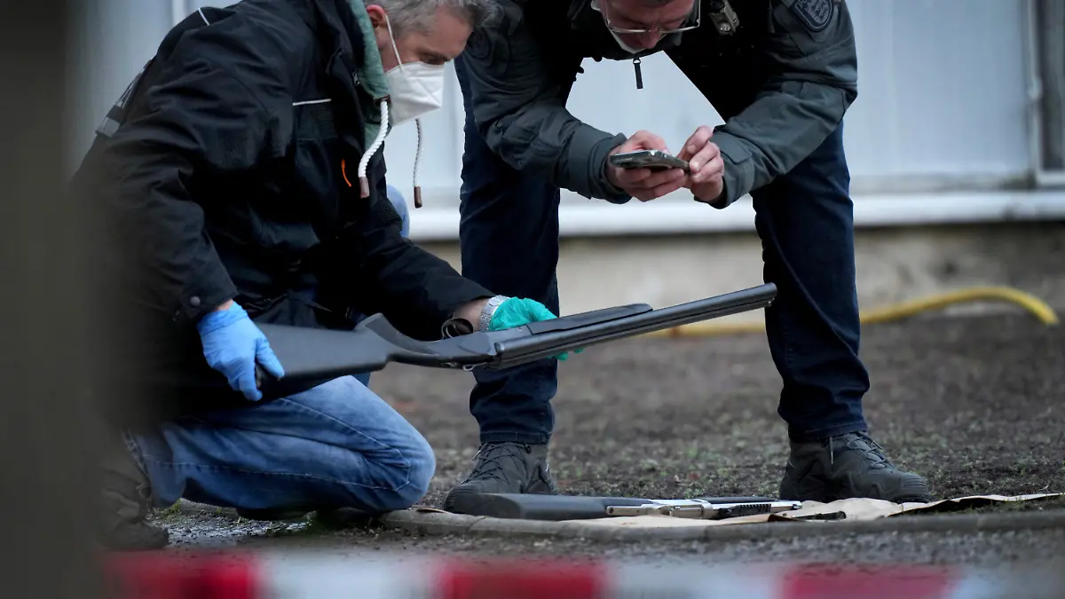 Police officers secure traces on the grounds of the Heidelberg University Botanical Garden in Heidelberg, Germany, Monday, Jan. 24, 2022. German police say a lone gunman wounded several people at a lecture theatre in the southwest city of Heidelberg on Monday. Police said in a brief statement that the perpetrator was dead but didn't give details of how that happened.(AP Photo/Michael Probst)