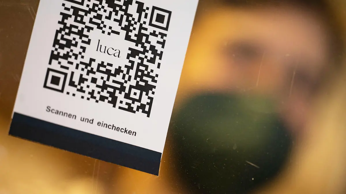 ARCHIV - 10.01.2022, Baden-Württemberg, Stuttgart: Ein Barcode, der mit der Luca-App zur Kontaktnachverfolgung gescannt werden kann, hängt in einem Einzelhandelsgeschäft an einer Schutzscheibe. (zu dpa «Gastronomen und Hoteliers wollen keine Kontaktdaten mehr erfassen») Foto: Marijan Murat/dpa +++ dpa-Bildfunk +++