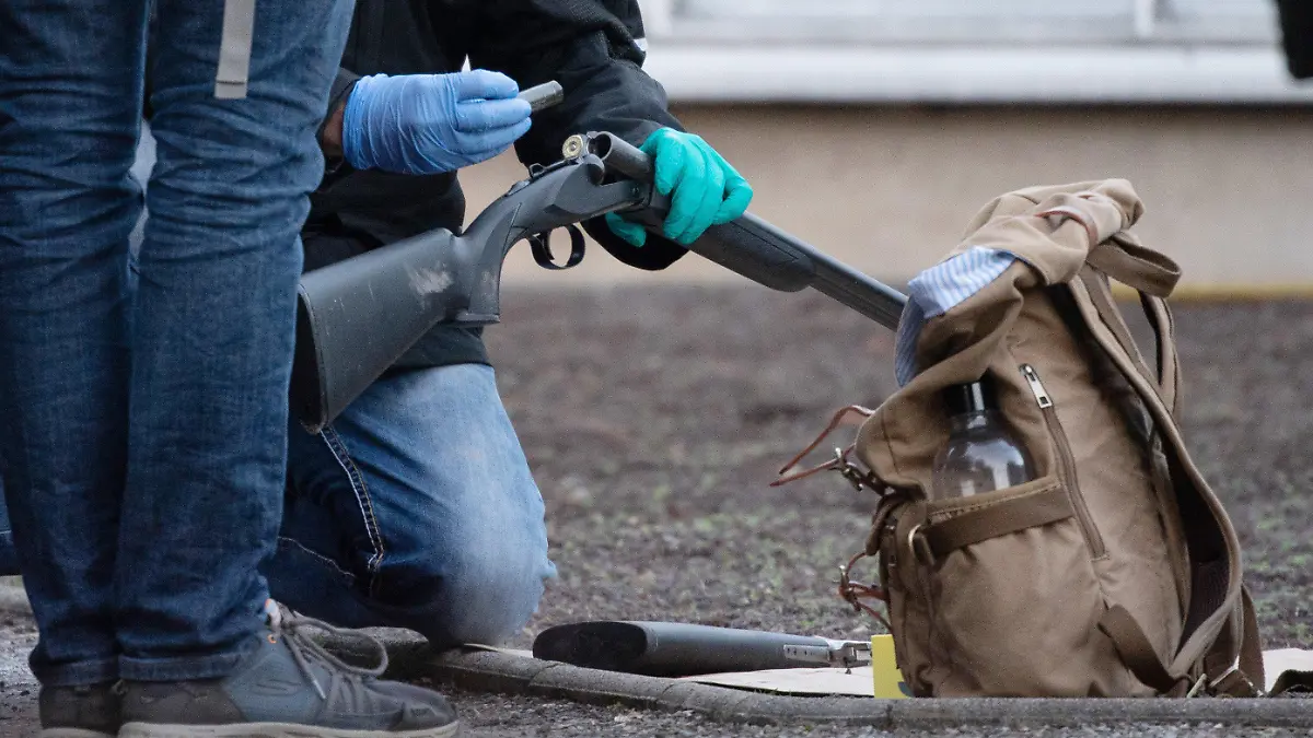 24.01.2022, Baden-Württemberg, Heidelberg: Polizeibeamte untersuchen eine Waffe am Gelände der Heidelberger Universität. Auf dem Campus der Heidelberger Universität hat es einen Amoklauf gegeben. Ein Einzeltäter habe am Montagmittag mit einer Langwaffe mehrere Menschen in einem Hörsaal verletzt, eine junge Frau ist wenige Stunden nach der Tat ihren schweren Verletzungen erlegen. Der Täter sei inzwischen tot Foto: Sebastian Gollnow/dpa +++ dpa-Bildfunk +++
