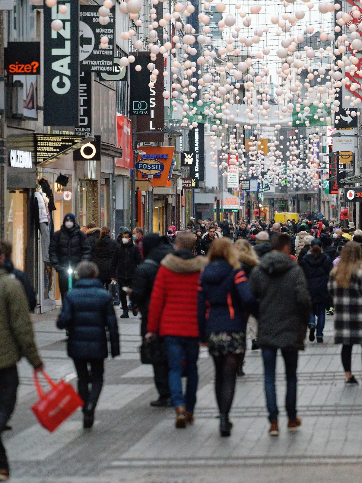 Menschen gehen am Vormittag des Heiligen Abends durch die Fußgängerzone Hohe Straße.