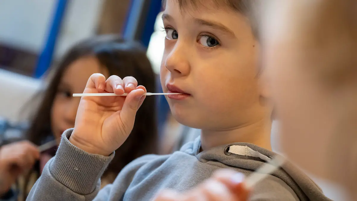 11.01.2022, Bayern, Augsburg: Die Kinder in einer Kindertagesstätte machen am Vormittag eine Corona-Pooltestung (Lollitest), die nun regelmäßig durchgeführt werden soll. Am Montag, 10.01.2022 haben in Bayern die Schulen und auch die meisten Kindertagesstätten wieder geöffnet - mit Änderungen bei den Vorgaben zu Corona-Tests für Krippen- und Kindergartenkinder. Foto: Peter Kneffel/dpa - ACHTUNG: Nur zur redaktionellen Verwendung im Zusammenhang mit einer Berichterstattung über diesen Termin und nur mit vollständiger Nennung des vorstehenden Credits +++ dpa-Bildfunk +++