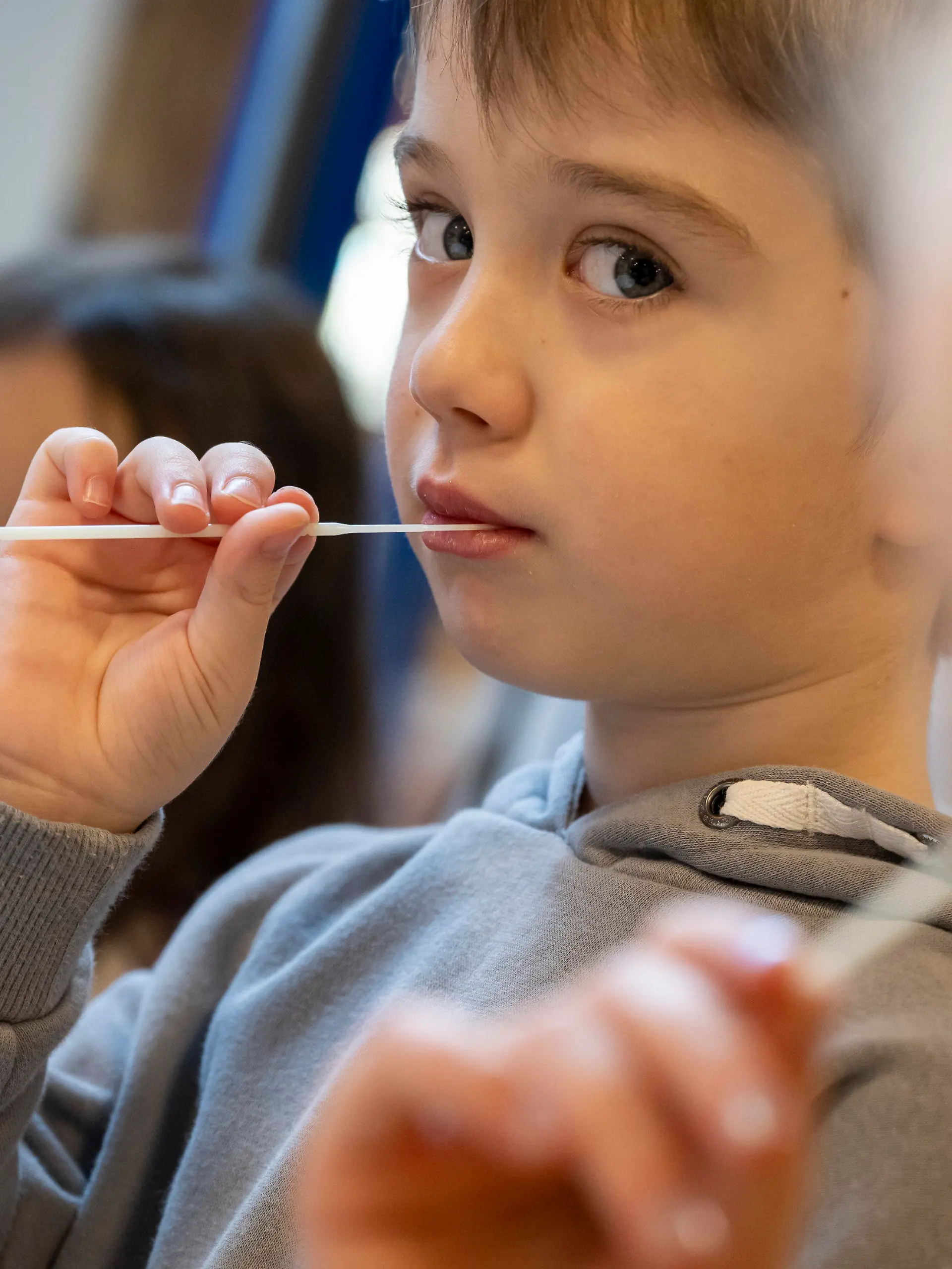 11.01.2022, Bayern, Augsburg: Die Kinder in einer Kindertagesstätte machen am Vormittag eine Corona-Pooltestung (Lollitest), die nun regelmäßig durchgeführt werden soll. Am Montag, 10.01.2022 haben in Bayern die Schulen und auch die meisten Kindertagesstätten wieder geöffnet - mit Änderungen bei den Vorgaben zu Corona-Tests für Krippen- und Kindergartenkinder. Foto: Peter Kneffel/dpa - ACHTUNG: Nur zur redaktionellen Verwendung im Zusammenhang mit einer Berichterstattung über diesen Termin und nur mit vollständiger Nennung des vorstehenden Credits +++ dpa-Bildfunk +++