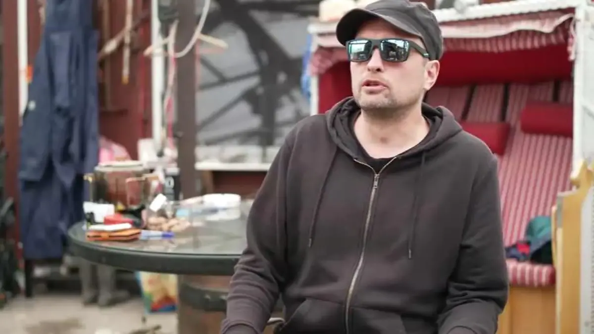 Mann mit Sonnenbrille und schwarzer Kleidung
