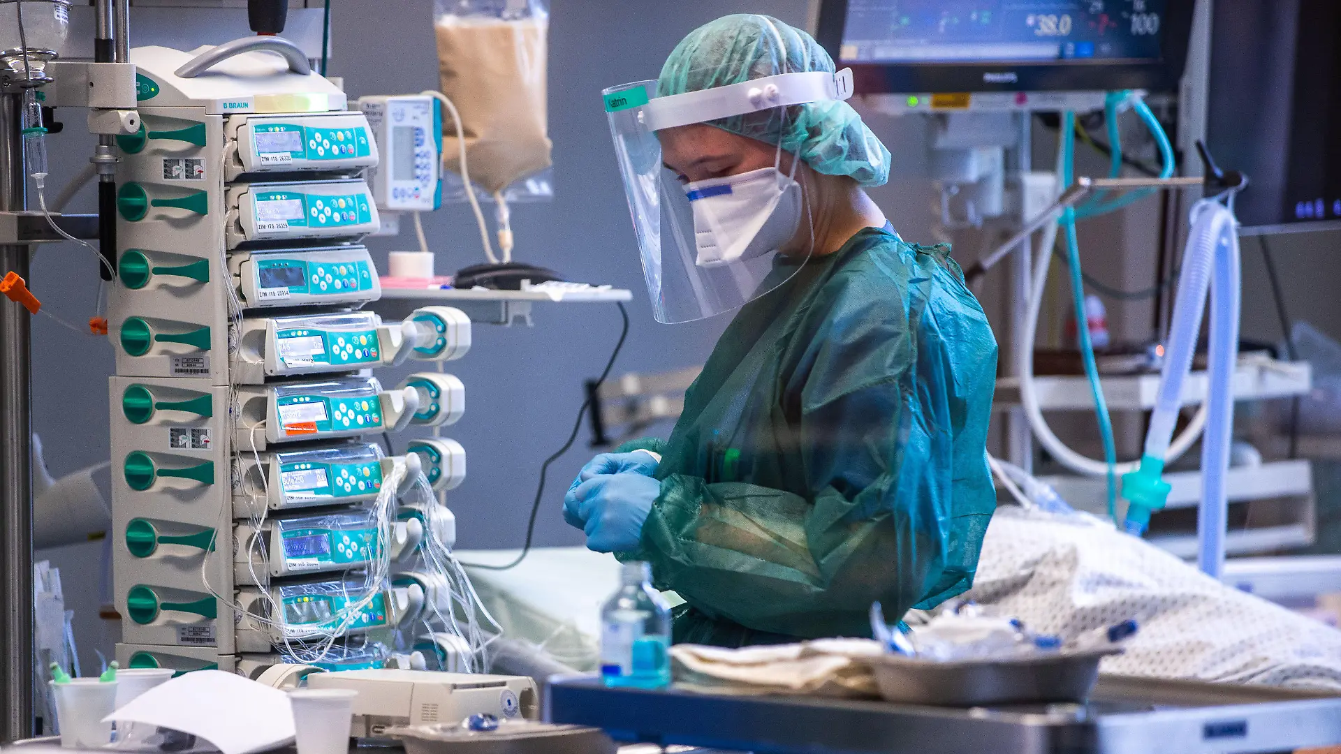 30.11.2021, Mecklenburg-Vorpommern, Rostock: Eine Intensivschwester betreut einen Patienten in einem der Behandlungszimmer der Intensivstation in der Universitätsmedizin Rostock. Angesichts der sprunghaft zunehmenden Zahl von Corona-Infizierten und der hohen Auslastung der Intensivstationen hat die Universitätsmedizin einen Covid-Ethikbeirat gebildet. Auch Patienten aus Sachsen werden in der Klinik behandelt. Foto: Jens Büttner/dpa-Zentralbild/dpa +++ dpa-Bildfunk +++