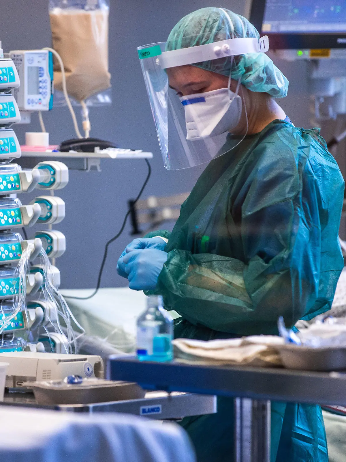 30.11.2021, Mecklenburg-Vorpommern, Rostock: Eine Intensivschwester betreut einen Patienten in einem der Behandlungszimmer der Intensivstation in der Universitätsmedizin Rostock. Angesichts der sprunghaft zunehmenden Zahl von Corona-Infizierten und der hohen Auslastung der Intensivstationen hat die Universitätsmedizin einen Covid-Ethikbeirat gebildet. Auch Patienten aus Sachsen werden in der Klinik behandelt. Foto: Jens Büttner/dpa-Zentralbild/dpa +++ dpa-Bildfunk +++