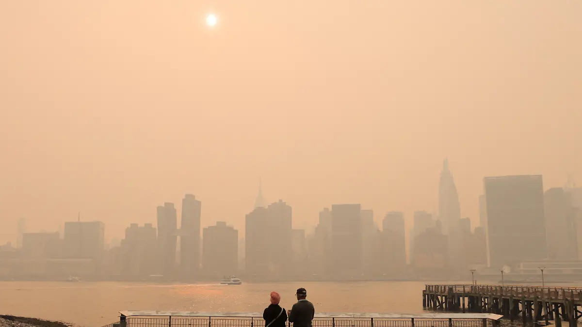 People watch the sunset as haze and smoke caused by wildfires in Canada hang over the Manhattan skyline, in New York City, New York, U.S., June 7, 2023. REUTERS/Andrew Kelly
