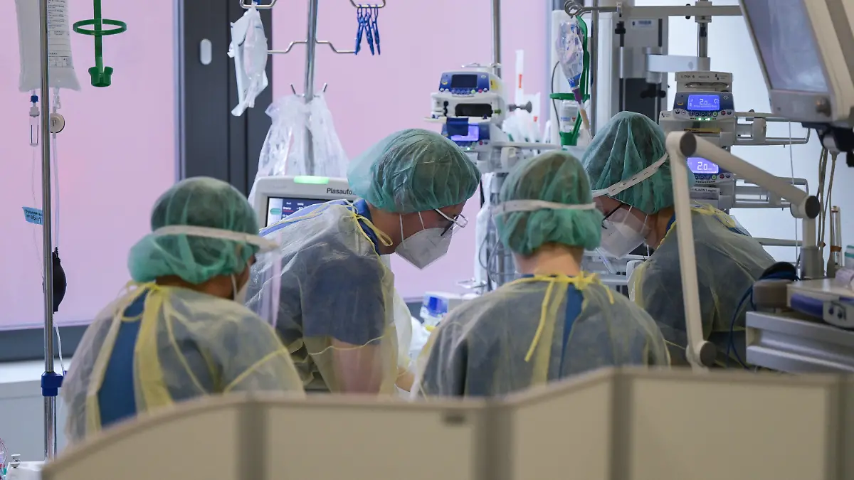 05.01.2022, Hessen, Offenbach am Main: Pfleger und Pflegerinnen sowie eine Ärztin kümmern sich auf der Intensivstation für Corona-Patienten am Sana Klinikum Offenbach um einen Patienten. Auf der Corona-Intensivstation sind momentan alle Betten bis auf zwei belegt. Die Coronainfektionszahlen im Rhein-Main-Gebiet steigen jedoch wieder an. Foto: Sebastian Gollnow/dpa +++ dpa-Bildfunk +++