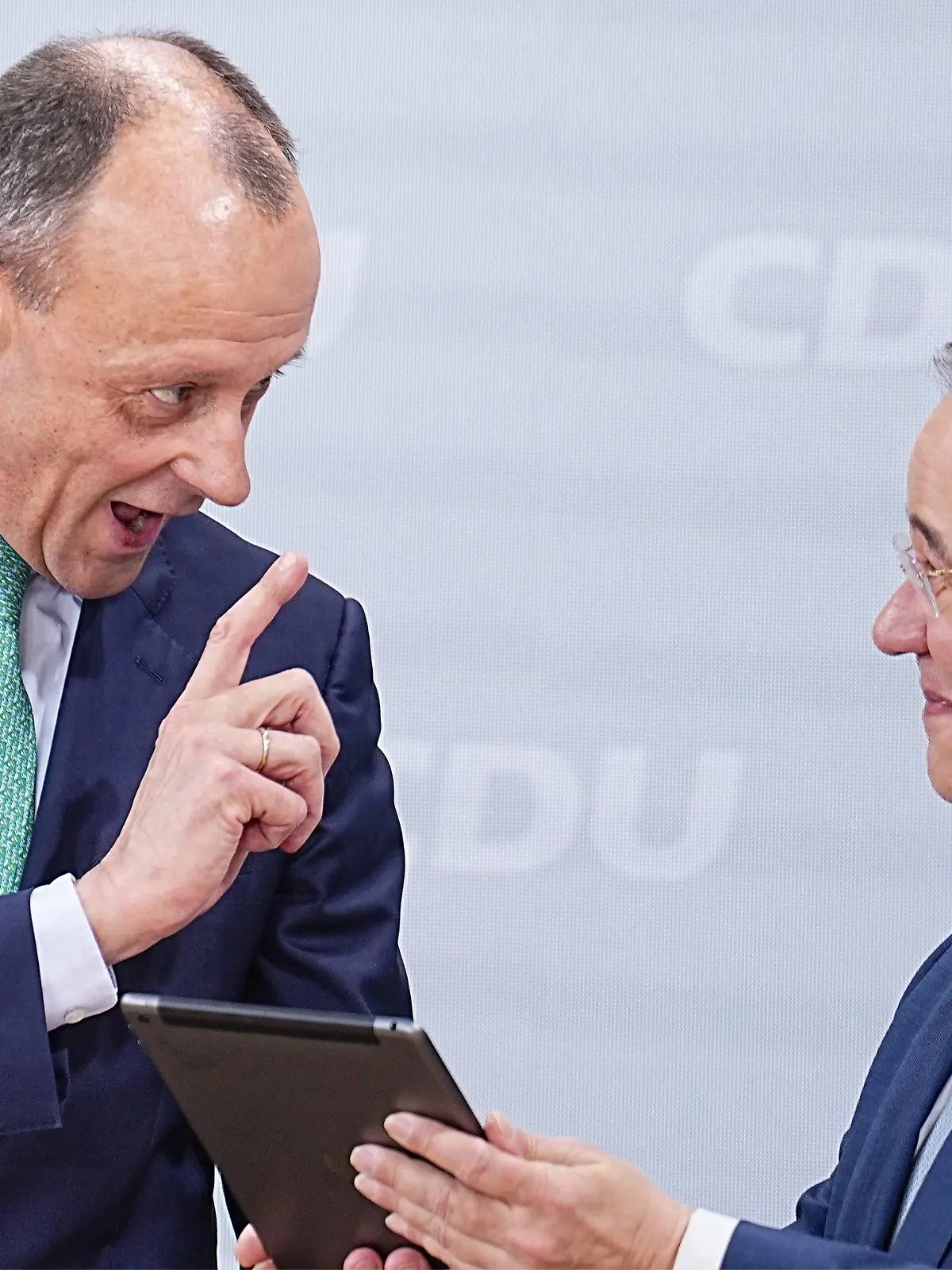 22.01.2022, Berlin: Friedrich Merz (l), Kandidat für das Amt des CDU Bundesvorsitzenden, überreicht dem scheidenden CDU-Bundesvorsitzenden Armin Laschet beim Bundesparteitag der CDU im Konrad-Adenauer-Haus ein iPad mit speziellen Apps. Beim 34. Parteitag der CDU soll Merz als neuer Bundesvorsitzender gewählt werden. Pandemiebedingt findet der Parteitag rein digital statt. Das Ergebnis der Wahl muss daher noch per Briefwahl bestätigt werden. Foto: Michael Kappeler/dpa +++ dpa-Bildfunk +++