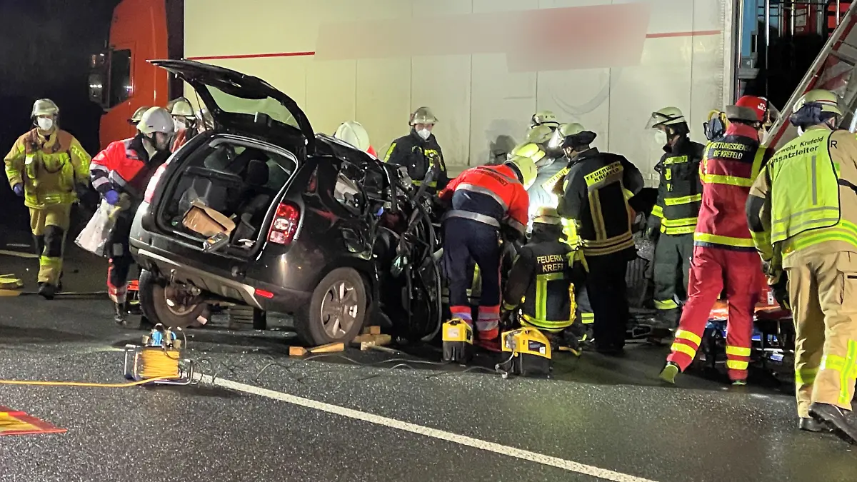22.01.2022, Nordrhein-Westfalen, Krefeld: Rettungskräfte arbeiten an einem PKW, der unter einen LKW-Auflieger geraten ist. Zwei Menschen sind bei einem Auffahrunfall auf der A57 schwer verletzt worden. Aus bislang ungeklärter Ursache war ein Auto am frühen Samstagmorgen auf einen Lkw aufgefahren, wie die Polizei mitteilte. Foto: Alexander Forstreuter/dpa +++ dpa-Bildfunk +++