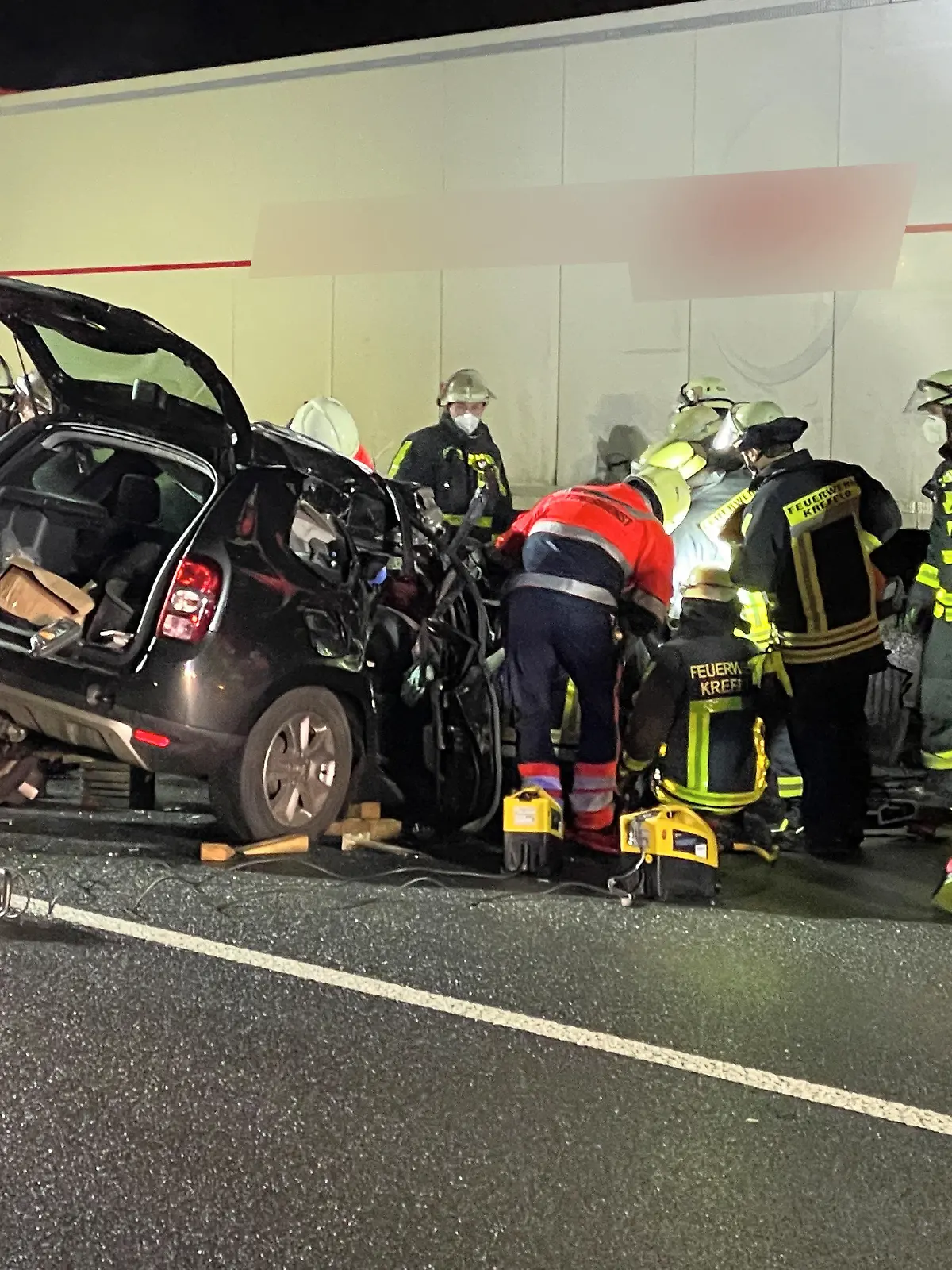 22.01.2022, Nordrhein-Westfalen, Krefeld: Rettungskräfte arbeiten an einem PKW, der unter einen LKW-Auflieger geraten ist. Zwei Menschen sind bei einem Auffahrunfall auf der A57 schwer verletzt worden. Aus bislang ungeklärter Ursache war ein Auto am frühen Samstagmorgen auf einen Lkw aufgefahren, wie die Polizei mitteilte. Foto: Alexander Forstreuter/dpa +++ dpa-Bildfunk +++