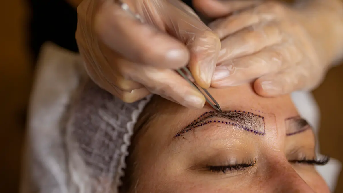 Make-up artist applying permanent make-up on eyebrows.