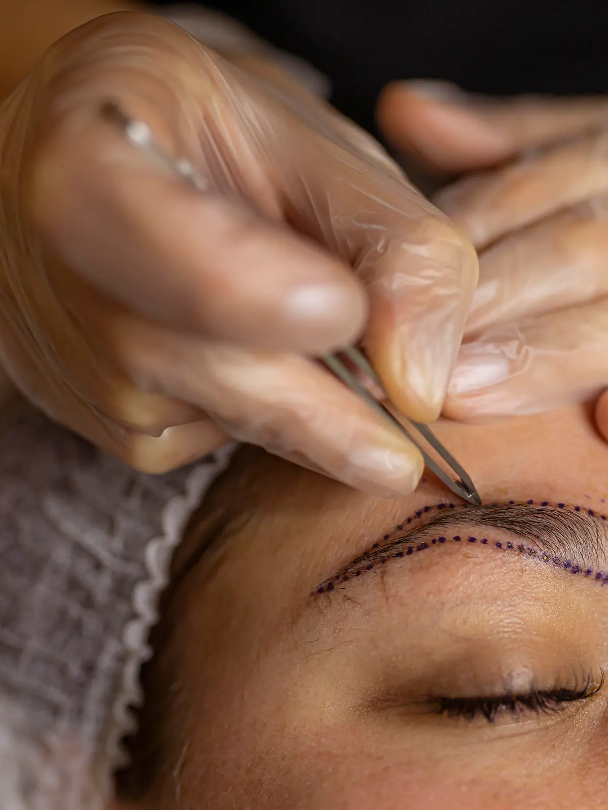 Make-up artist applying permanent make-up on eyebrows.