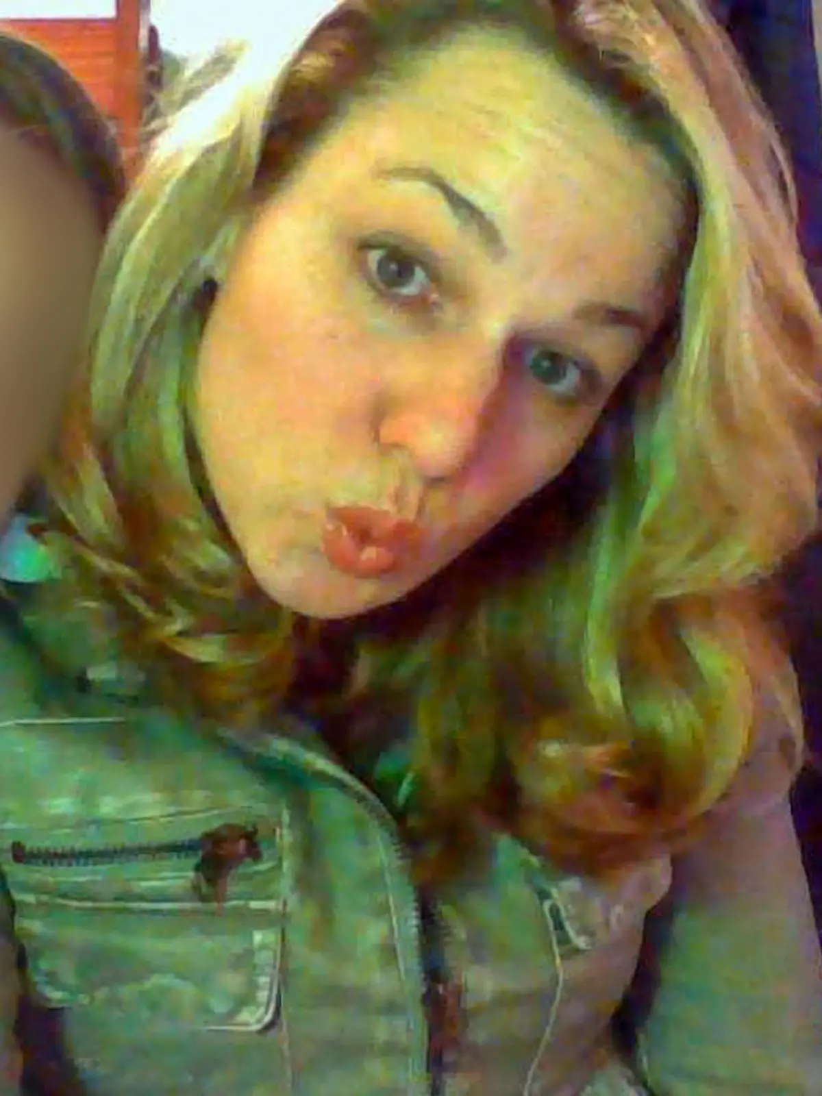 Eine junge Frau mit blonden Haaren verzieht ihren Mund zu einer Grimase.