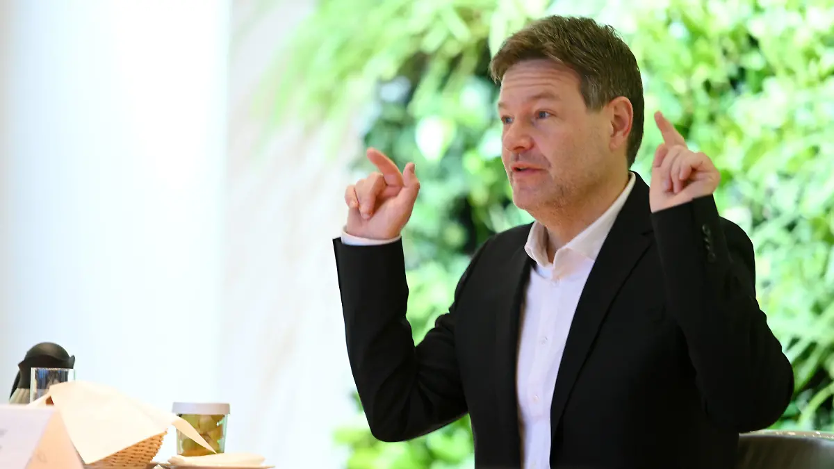 20.01.2022, Bayern, München: Robert Habeck (Bündnis 90/Die Grünen - r), Bundesminister für Wirtschaft und Klimaschutz, sitzt in der Staatskanzlei am Tisch und gestikuliert. Habeck kam mit dem bayerischen Ministerspräsidenten zu Gesprächen zusammen. Ein wichtiges Thema bei Habecks Treffen mit bayerischen Regierungsvertretern werden die strengen Abstandsregelungen für Windräder in Bayern sein, die den Ausbau der Windkraft im Freistaat ausbremsen. Foto: Tobias Hase/dpa +++ dpa-Bildfunk +++
