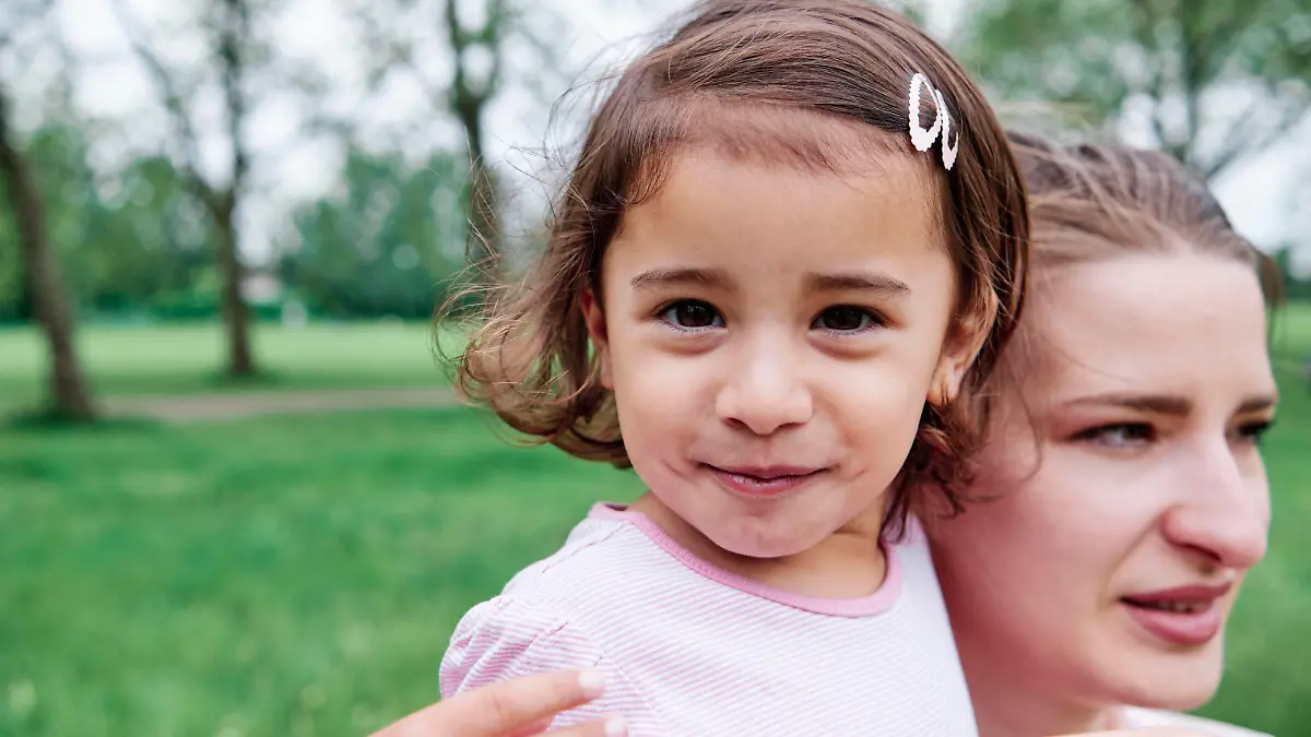 Cute daughter with mother at park model released Symbolfoto ASGF00694