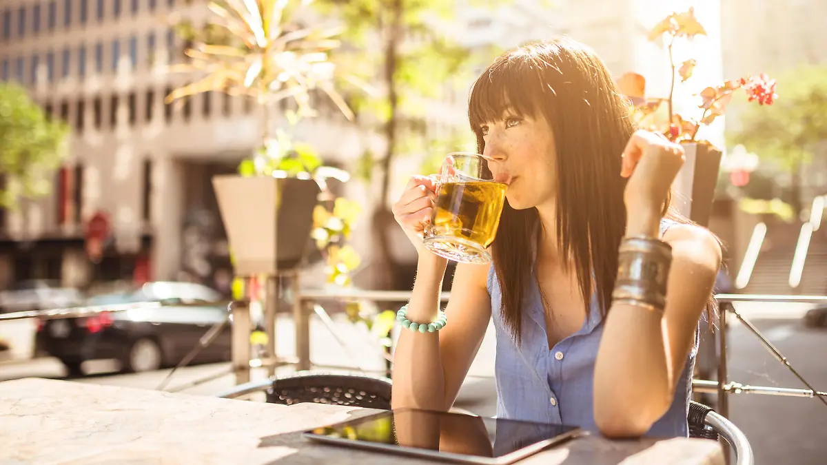 young woman drinking a tea on the city