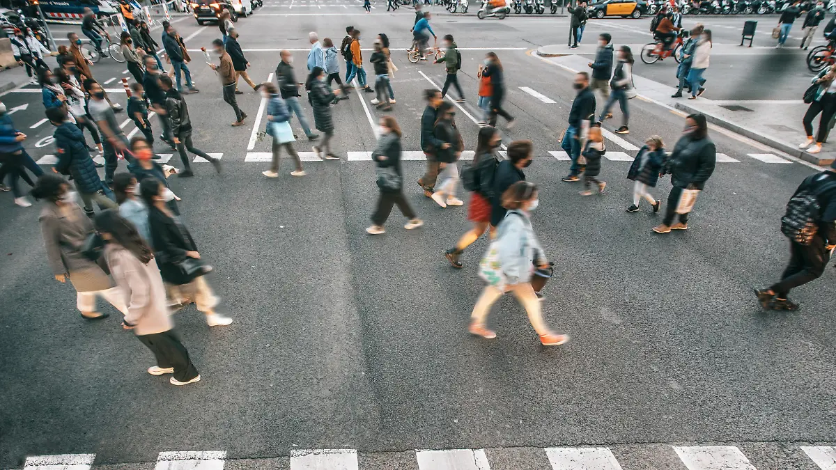 People wearing masks walking on zebra crossing