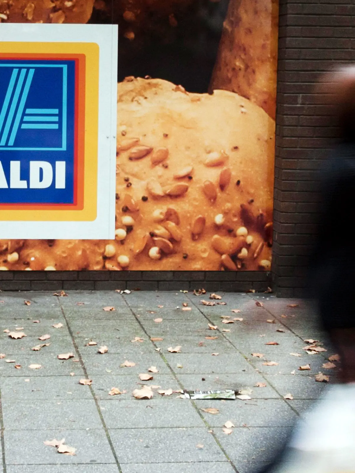 ARCHIV - 29.09.2014, Großbritannien, London: Eine Frau geht an einem Aldi-Supermarkt in London vorbei. Bis Ende 2021 will der Lebensmittel-Discounter Aldi in Großbritannien trotz unsicherer Brexit-Aussichten 100 neue Filialen eröffnen. (Zu dpa "Aldi will trotz Brexits in Großbritannien 100 neue Filialen eröffnen") Foto: Will Oliver/epa/dpa +++ dpa-Bildfunk +++