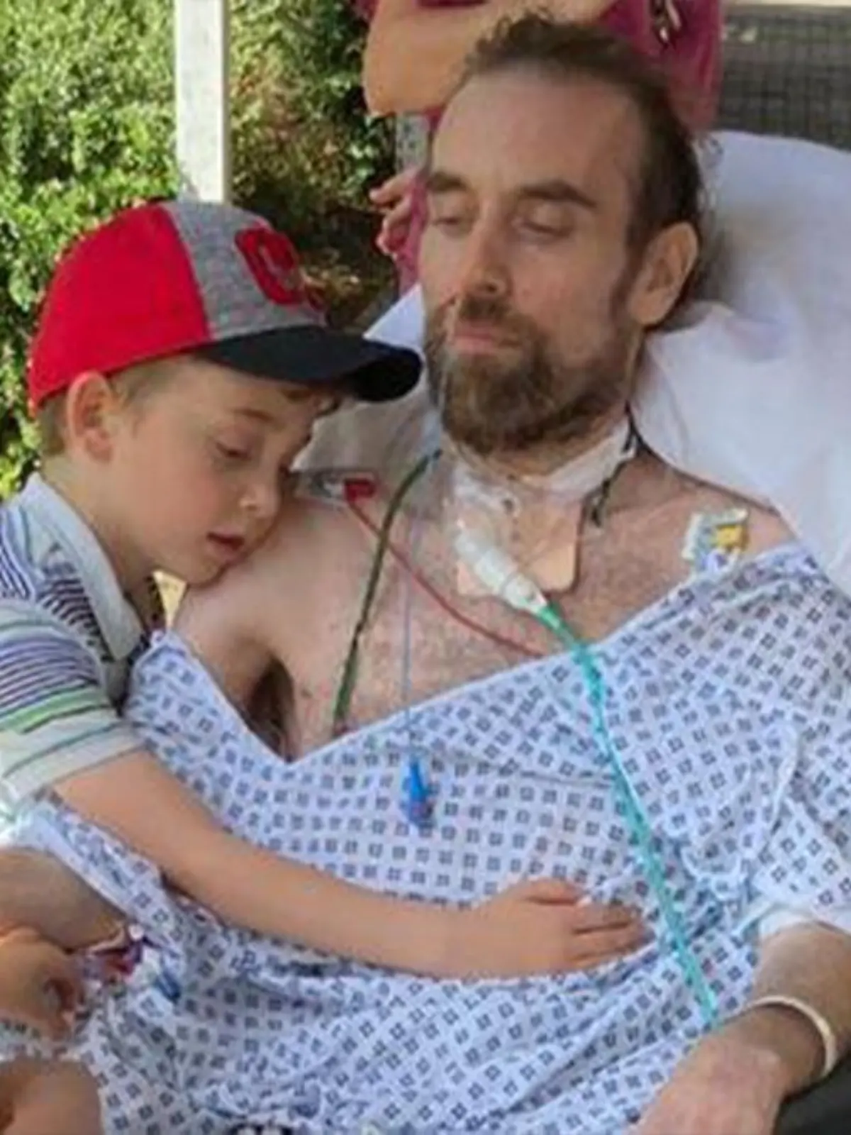 Familienvater Andrew Watts mit seinen beiden Kinder in einem Krankenhausbett
