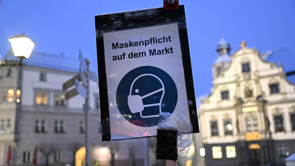 20.01.2022, Baden-Württemberg, Wangen im Allgäu: Ein Schild weist in der Innenstadt Wangen im Allgäu auf die Maskenpflicht auf dem Markt hin. In der Nacht hat es im Allgäu zu Schneien begonnen. Foto: Felix Kästle/dpa +++ dpa-Bildfunk +++