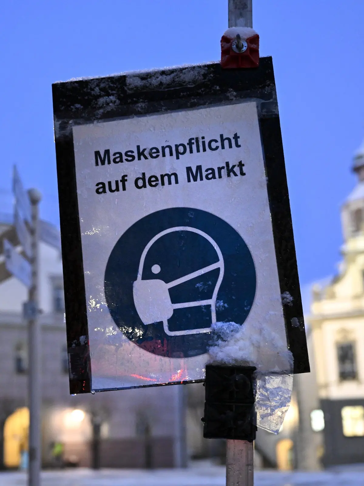 20.01.2022, Baden-Württemberg, Wangen im Allgäu: Ein Schild weist in der Innenstadt Wangen im Allgäu auf die Maskenpflicht auf dem Markt hin. In der Nacht hat es im Allgäu zu Schneien begonnen. Foto: Felix Kästle/dpa +++ dpa-Bildfunk +++