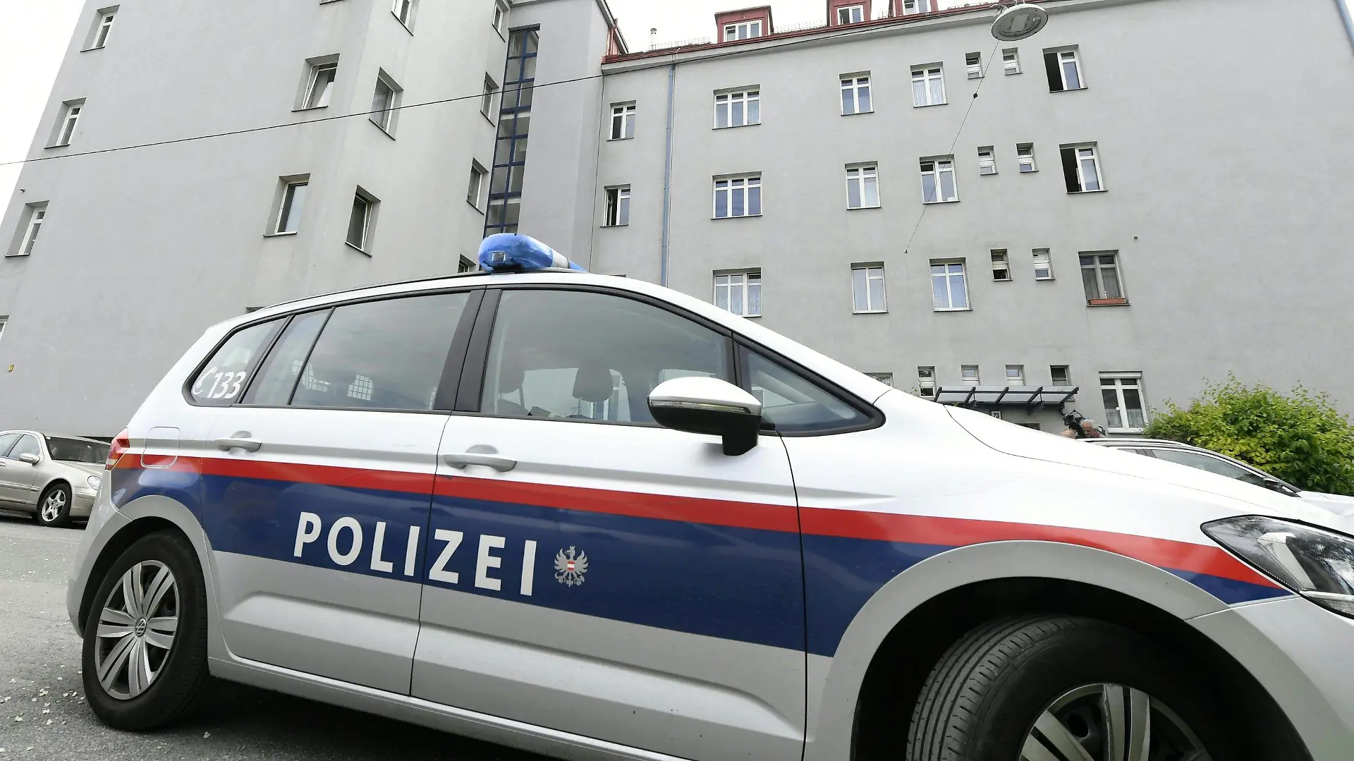 21.05.2019, Österreich, Wien: Ein Polizeifahrzeug steht vor einem Wohngebäude. Die Leichen von drei Frauen sind in einer Wohnung in Wien gefunden worden. Wie die Polizei am Dienstag mitteilte, gehen die Ermittler derzeit davon aus, dass es sich bei den Toten um eine 45 Jahre alte Frau und ihre etwa 17 Jahre alten Töchter handelt. Nähere Hintergründe sowie die Todesursachen waren zunächst noch völlig unklar, auch die Identitäten der drei Frauen waren nach Polizeiangaben noch nicht bestätigt. Foto: Hans Klaus Techt/APA/dpa +++ dpa-Bildfunk +++