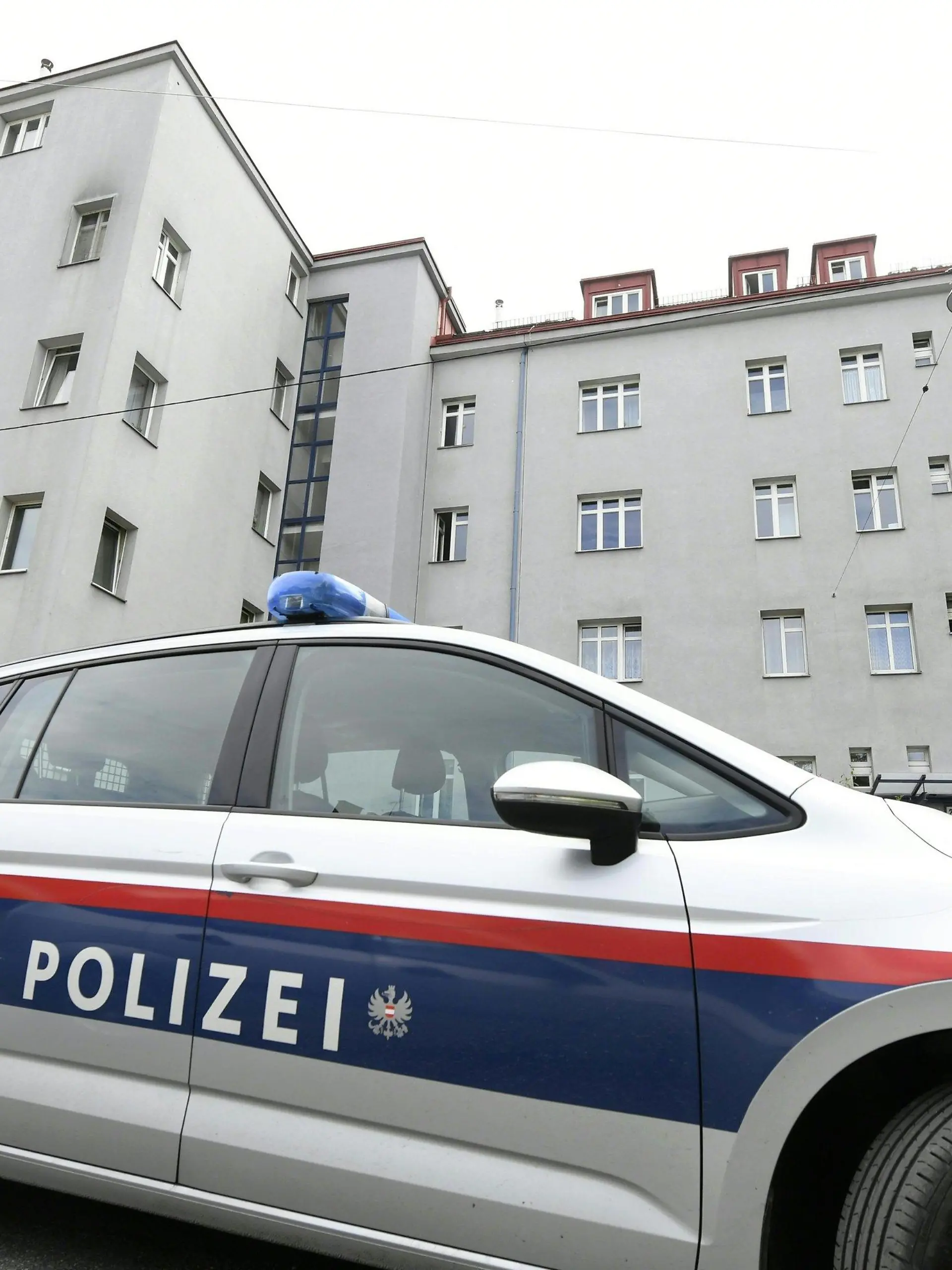 21.05.2019, Österreich, Wien: Ein Polizeifahrzeug steht vor einem Wohngebäude. Die Leichen von drei Frauen sind in einer Wohnung in Wien gefunden worden. Wie die Polizei am Dienstag mitteilte, gehen die Ermittler derzeit davon aus, dass es sich bei den Toten um eine 45 Jahre alte Frau und ihre etwa 17 Jahre alten Töchter handelt. Nähere Hintergründe sowie die Todesursachen waren zunächst noch völlig unklar, auch die Identitäten der drei Frauen waren nach Polizeiangaben noch nicht bestätigt. Foto: Hans Klaus Techt/APA/dpa +++ dpa-Bildfunk +++