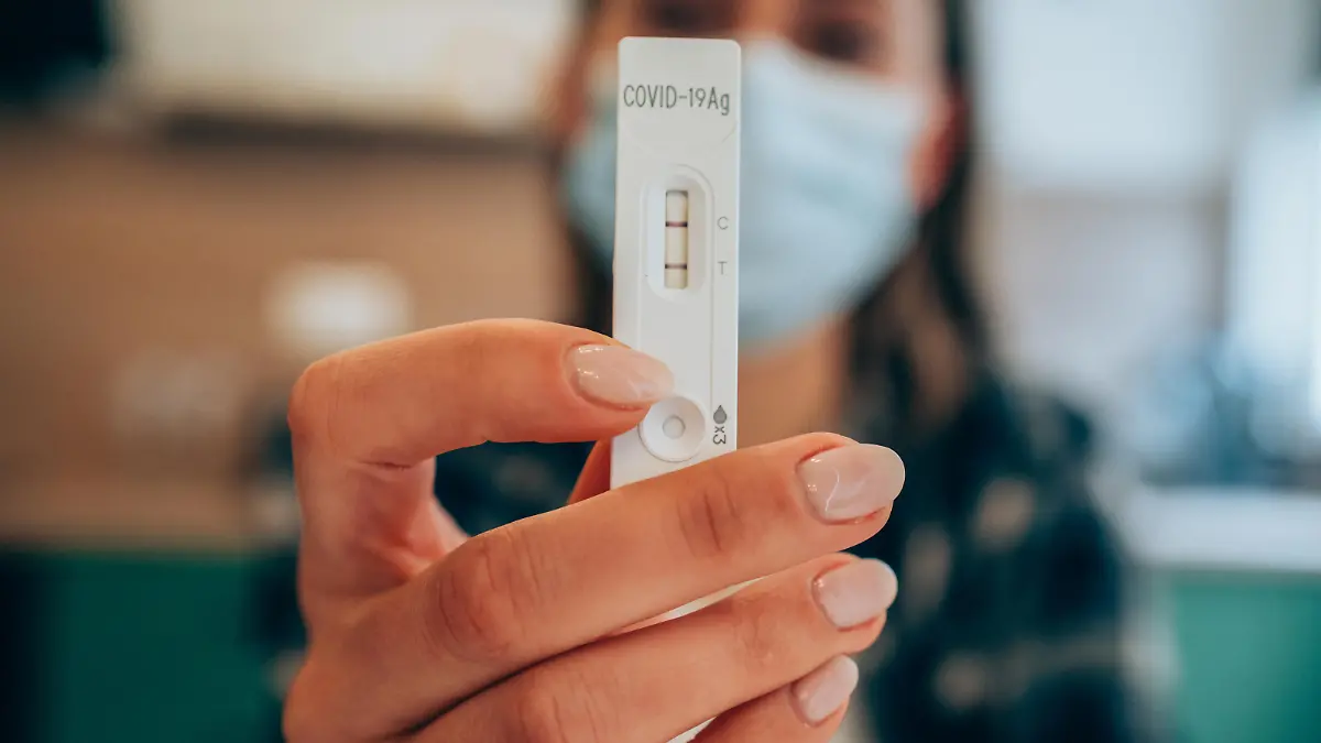 Frau zeigt positiven Corona-Test in die Kamera