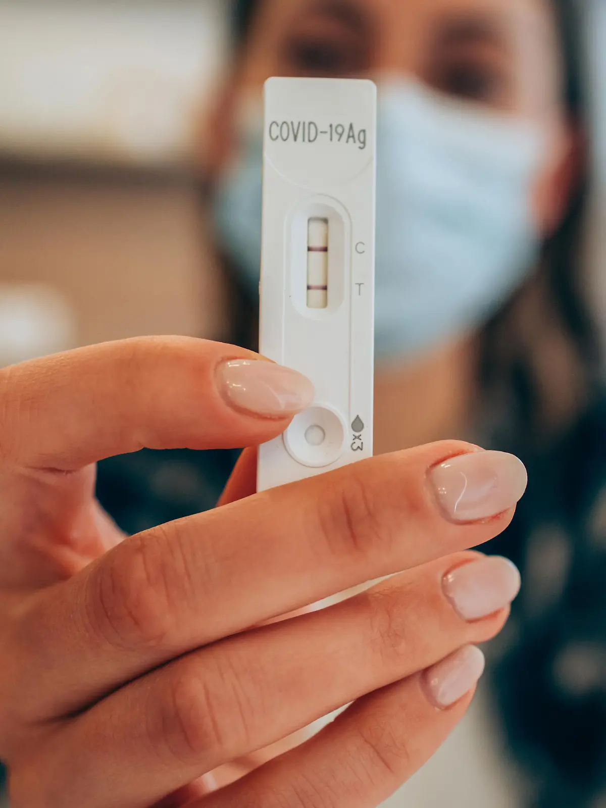 Frau zeigt positiven Corona-Test in die Kamera