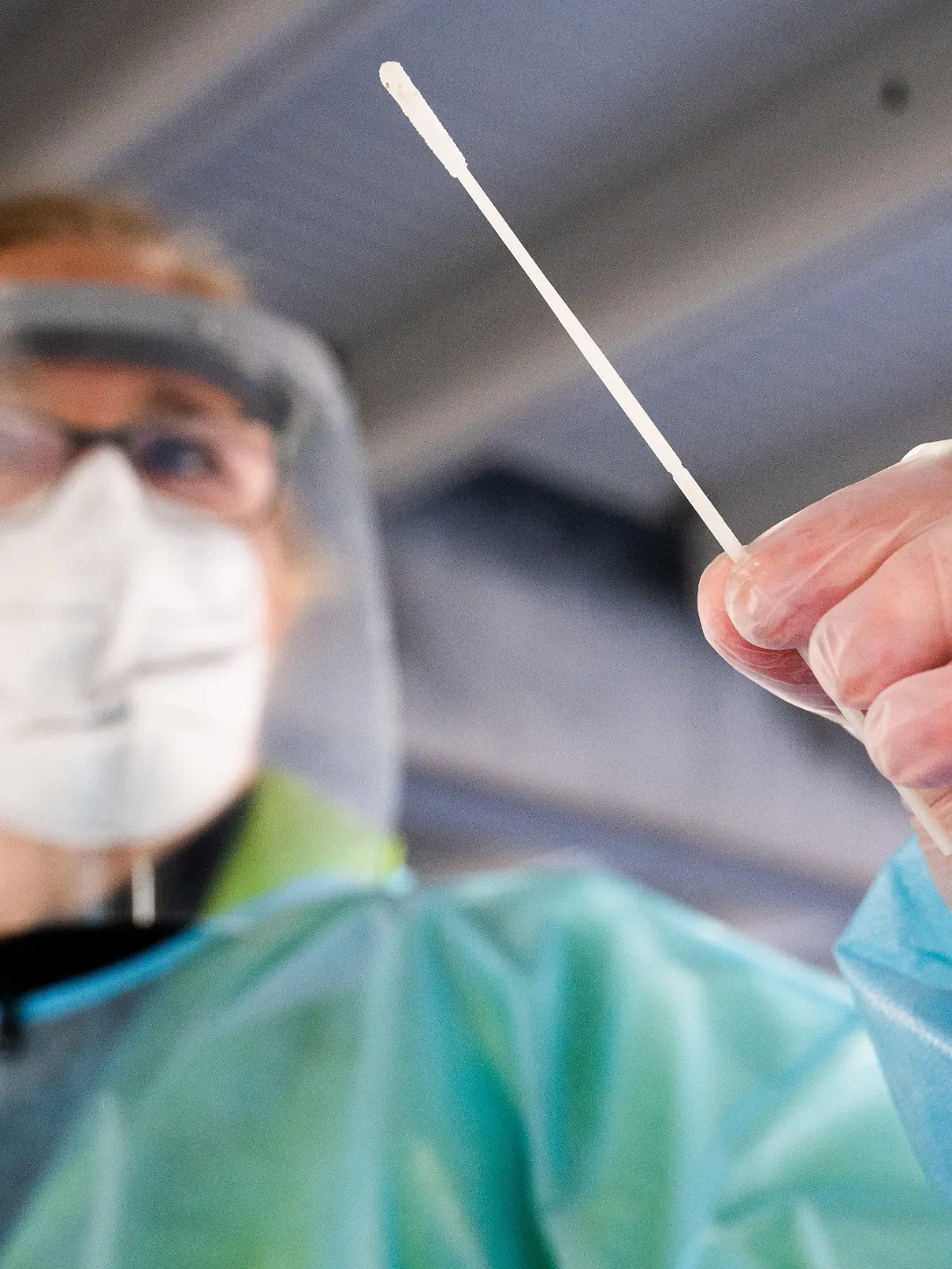 31.03.2021, Niedersachsen, Hannover: Eine Helferin hält einen Teststab im ·Testzentrum am Zoo· bei einem Schnelltest auf das Coronavirus. Das Robert Koch-Institut (RKI) vermeldet weiterhin steigende Corona-Neuinfektionen in Deutschland. Foto: Julian Stratenschulte/dpa +++ dpa-Bildfunk +++