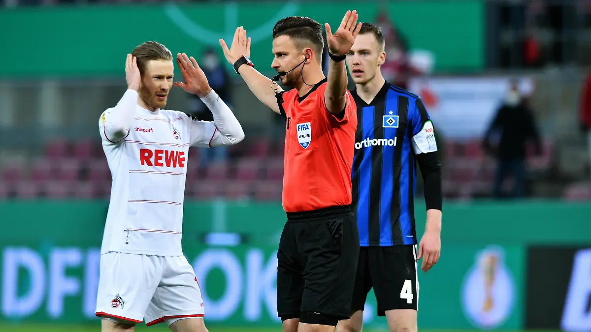 Fussball, Deutschland, Herren, DFB-Pokal Achtelfinale, Saison 2021/2022, Rhein Energie Stadion Köln, 1. FC Köln weiss - Hamburger SV blau 3:4 n.E. Schiedsrichter Daniel Schlager entscheidet den Elfmeter von Florian Kainz KOE für ungültig und beendet das Elfmeterschiessen. DFB/DFL REGULATIONS PROHIBIT ANY USE OF PHOTOGRAPHS AS IMAGE SEQUENCES AND/OR QUASI-VIDEO