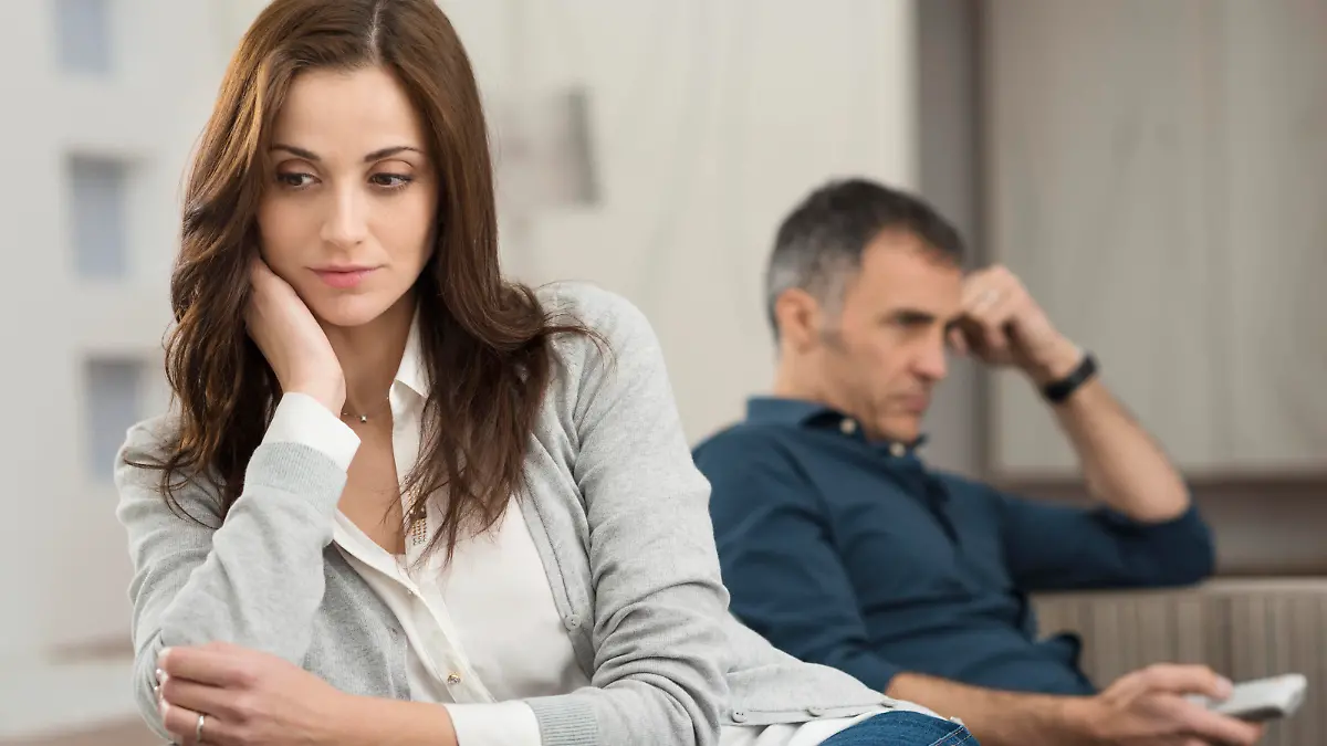 Sad Couple Sitting On Couch After Having Quarrel