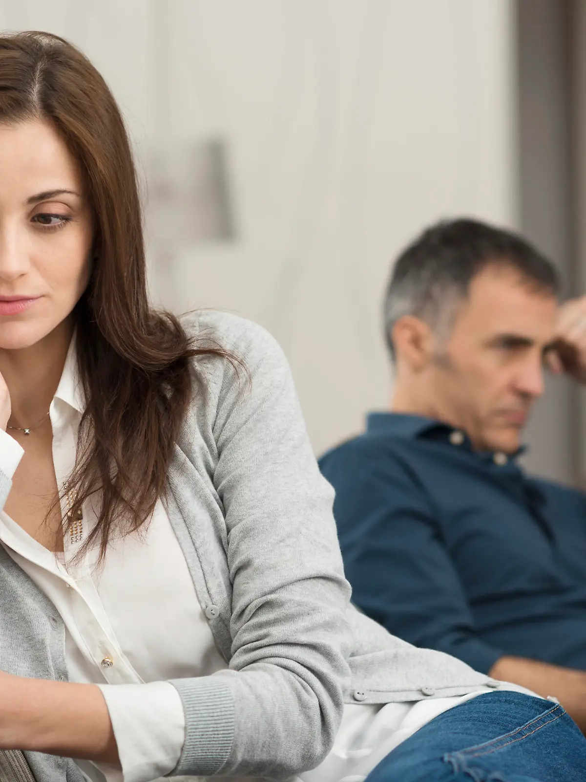 Sad Couple Sitting On Couch After Having Quarrel