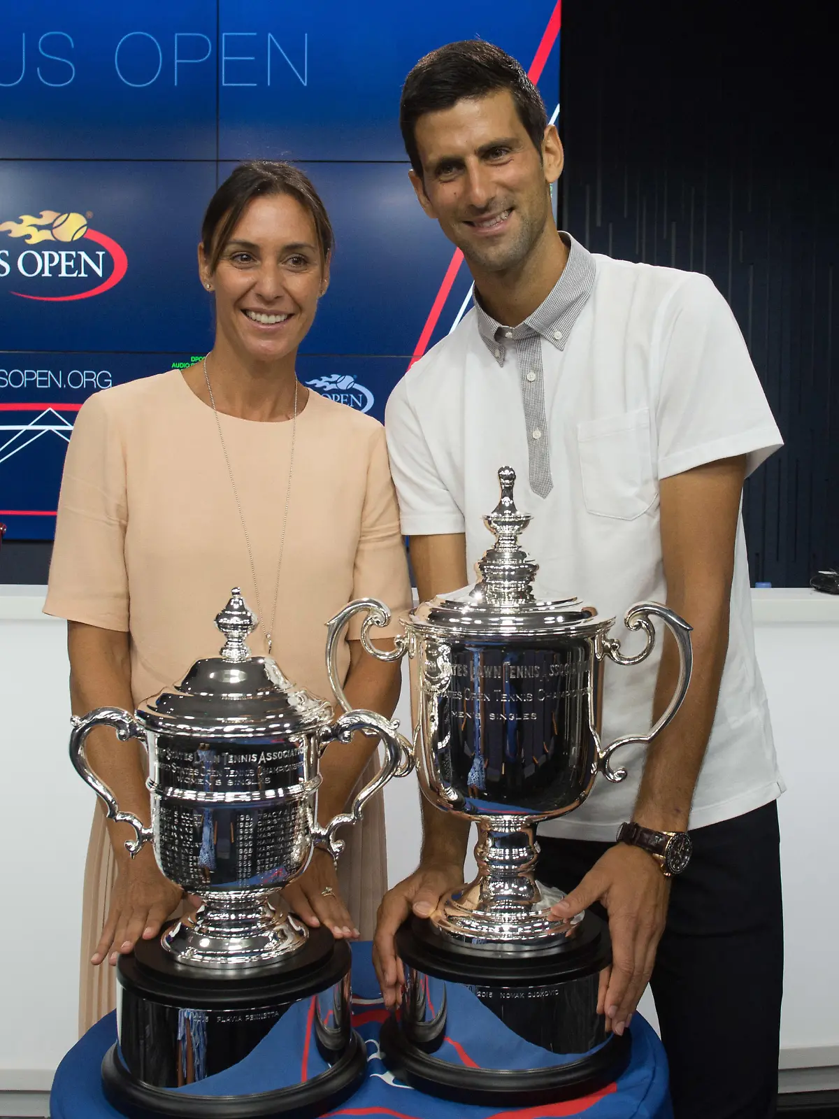 Reigning U.S. Open tennis champions Flavia Pennetta, left and Novak Djokovic, pose with their trophies during a media availability at the Billie Jean King National Tennis Center, Friday, Aug. 26, 2016, in New York. (AP Photo/Bryan R. Smith)