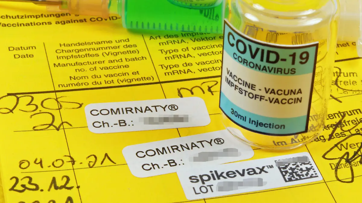 Booster Covid-19 Eintrag in einem Impfpass nach Impfung mit Moderna Impfstoff mit Impfampulle. Booster Impfung-Covid-19 *** Booster Covid 19 Entry in a vaccination certificate after vaccination with Moderna vaccine with vaccine ampoule Booster vaccination Covid 19