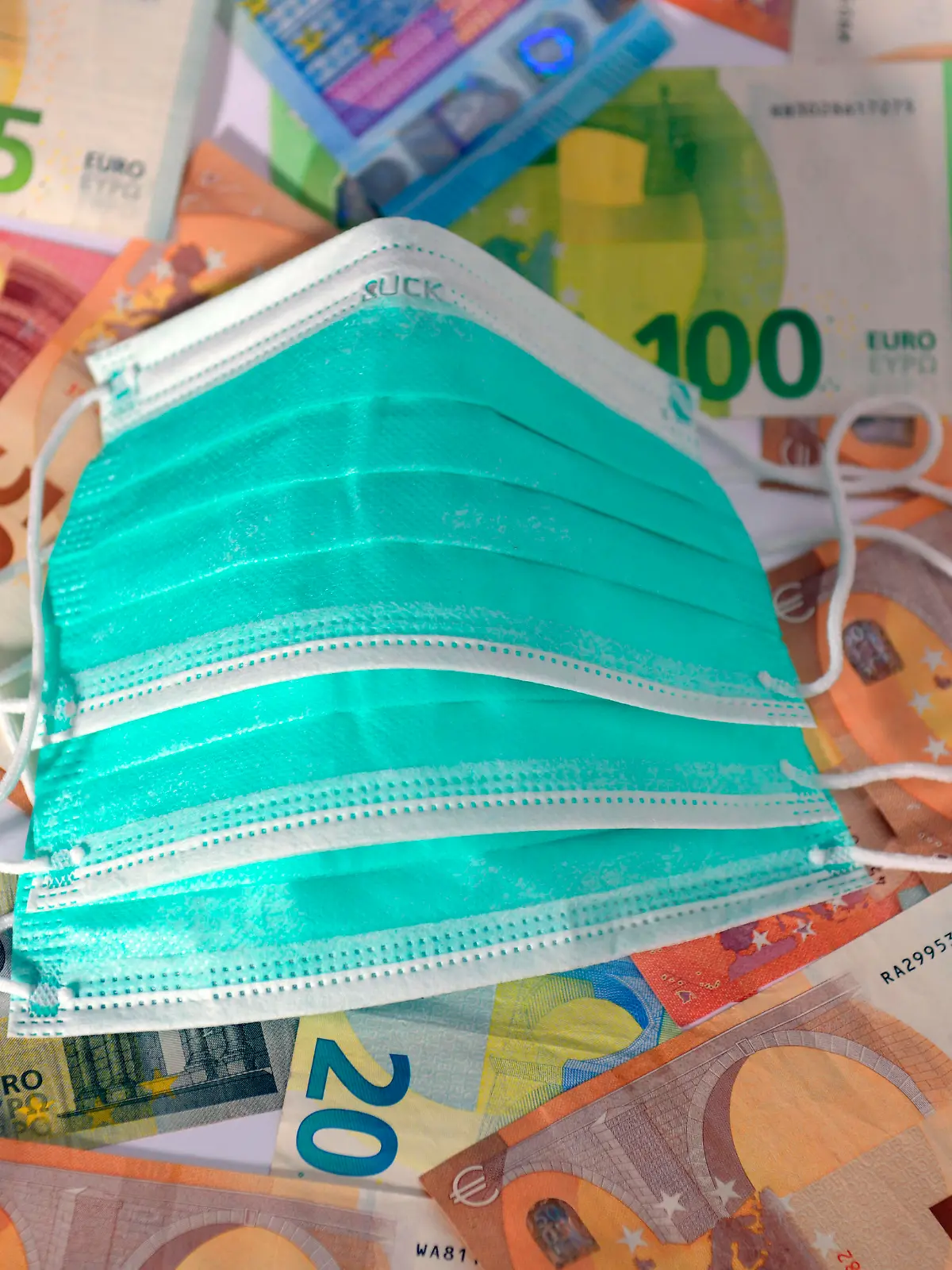 30.03.2020, Symbolbild, Corona-Krise und die Finanziellen Auswirkungen. Mundschutz liegt auf Euro-Banknoten. 30.03.2020, Kosten für Corona-Krise 30.03.2020, Kosten für Corona-Krise *** 30 03 2020, symbolic image, corona crisis and the financial impact Mouthguard lies on euro banknotes 30 03 2020, cost of corona crisis 30 03 2020, cost of corona crisis 