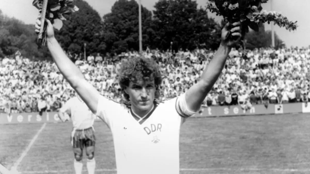 Hans-Jürgen "Dixie" Dörner, der Libero der DDR-Fußballnationalmannschaft, grüßt mit Blumen am 18.05.1985 im Potsdam-Babelsberger Karl-Liebknecht-Stadion ins Publikum. Er wird vor dem WM-Qualifikationsspiel gegen Luxemburg (3:1) vor 9.000 Zuschauern für sein 100. (und letztes) Länderspiel geehrt. Dörner kam zwischen 1969 und 1985 auf diese Zahl (9 Tore). Er spielte 19 Jahre für die Dresdner Dynamo-Mannschaft. Foto: Gert Kilian. +++(c) dpa - Report+++