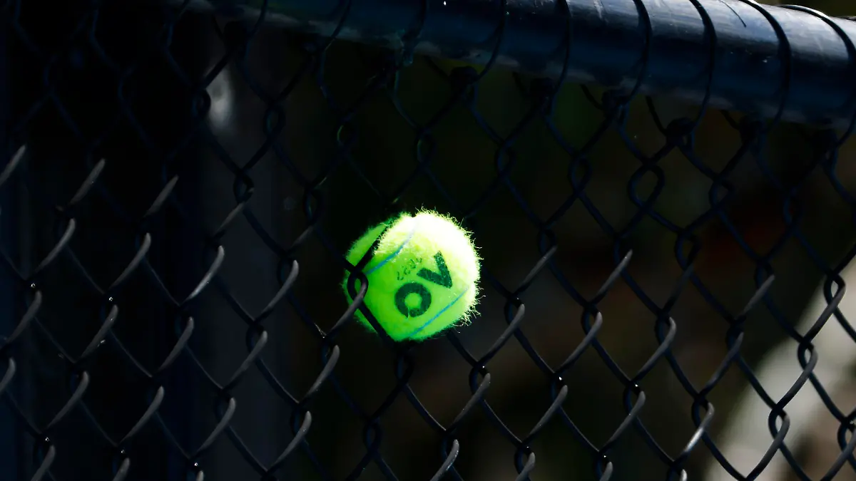 17.01.2022, Australien, Melbourne: Tennis: Grand Slam - Australian Open: Ein Tennisball steckt zwischen den Maschen eines Zauns fest. Foto: Frank Molter/dpa +++ dpa-Bildfunk +++