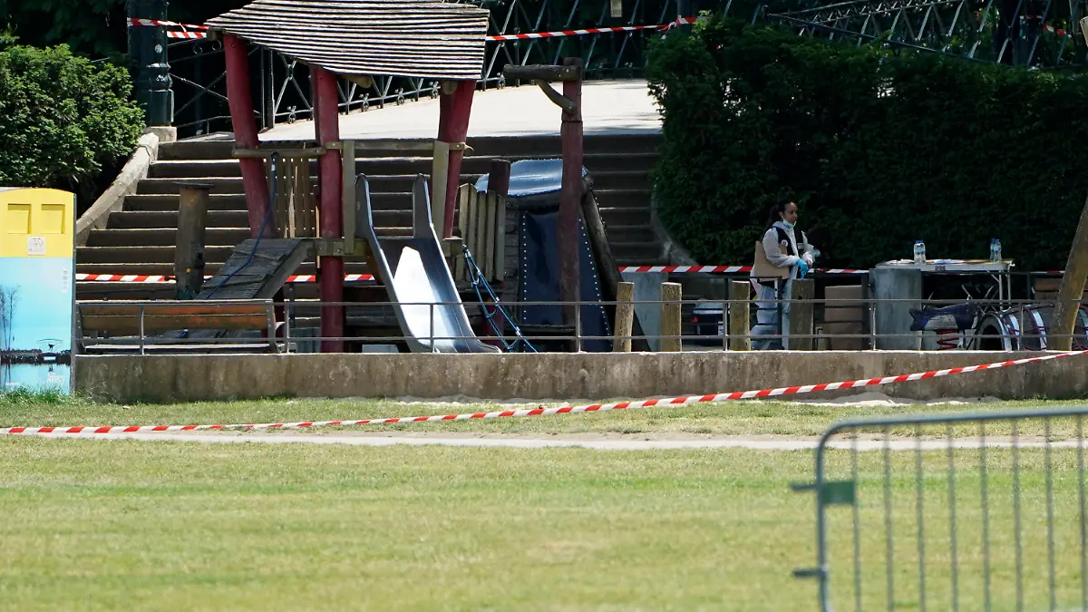 A police officer investigates at the scene after a knife attack Thursday, June 8, 2023 in Annecy, French Alps. A man with a knife stabbed several very young children, including at least one in a stroller, and also assaulted adults in a lakeside park in the French Alps. The savagery left at least two children and one adult with life-threatening injuries, authorities said. (AP Photo/Laurent Cipriani)