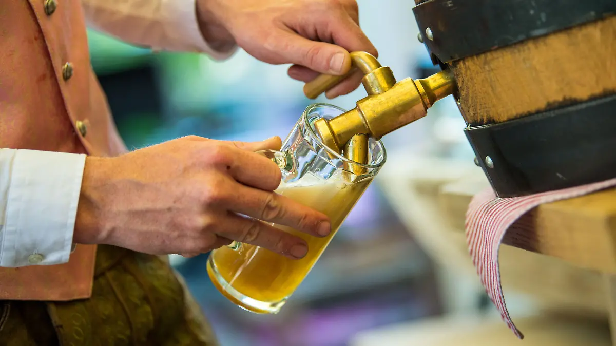 ARCHIV - 25.07.2018, Bayern, München: Ein Wirt schenkt bei einem Pressetermin zur Vorstellung des Wiesn-Wirtekrug für das Oktoberfest ein helles Bier ein (zu dpa «Sommerwetter lässt Bayerns Brauer jubeln» vom 30.07.2018). Foto: Lino Mirgeler/dpa +++ dpa-Bildfunk +++