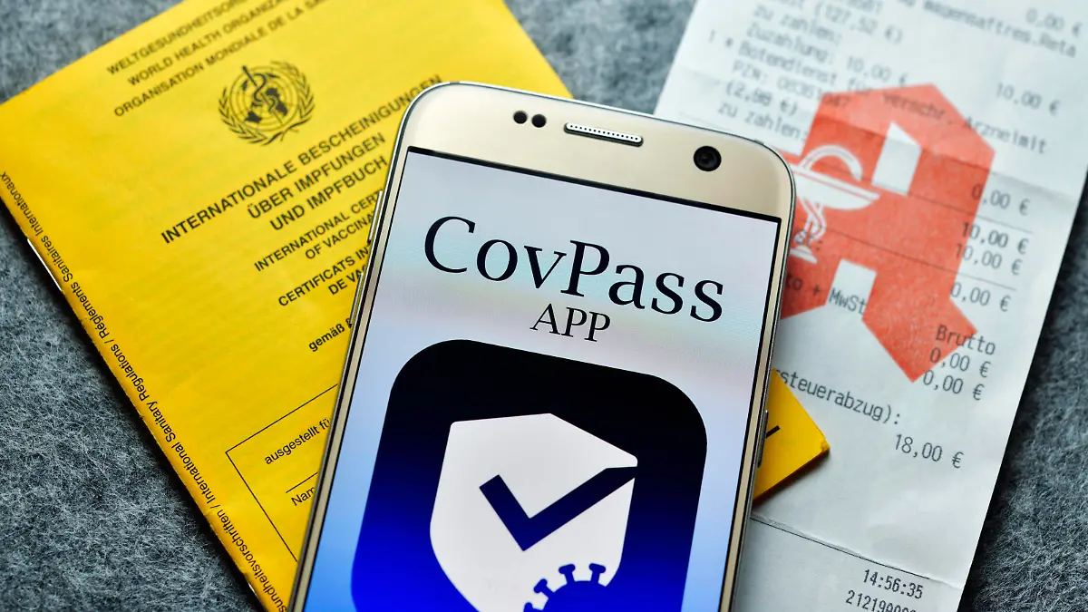 Smartphone mit Impfpass-App, Impfausweis und Apotheken-Kassenzettel, Symbolfoto digitaler Impfnachweis *** Smartphone with vaccination card app, vaccination card and pharmacy receipt, symbol photo digital proof of vaccination