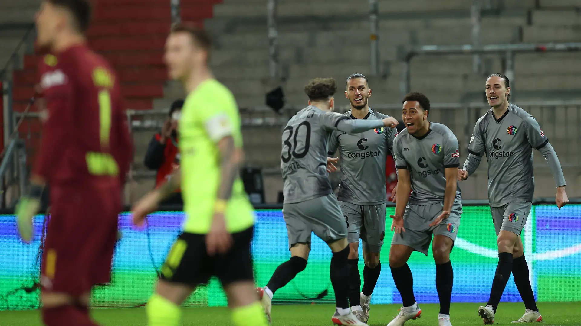 Fußball: DFB-Pokal, FC St. Pauli - Borussia Dortmund, Achtelfinale, Millerntor-Stadion. St. -Paulis Amenyido (2.v.r.) bejubelt sein Tor zum 1:0 mit seiner Mannschaft. (WICHTIGER HINWEIS: Gemäß den Vorgaben der DFL Deutsche Fußball Liga bzw. des DFB Deutscher Fußball-Bund ist es untersagt, in dem Stadion und/oder vom Spiel angefertigte Fotoaufnahmen in Form von Sequenzbildern und/oder videoähnlichen Fotostrecken zu verwerten bzw. verwerten zu lassen.)