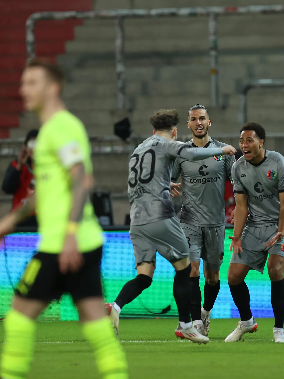 Fußball: DFB-Pokal, FC St. Pauli - Borussia Dortmund, Achtelfinale, Millerntor-Stadion. St. -Paulis Amenyido (2.v.r.) bejubelt sein Tor zum 1:0 mit seiner Mannschaft. (WICHTIGER HINWEIS: Gemäß den Vorgaben der DFL Deutsche Fußball Liga bzw. des DFB Deutscher Fußball-Bund ist es untersagt, in dem Stadion und/oder vom Spiel angefertigte Fotoaufnahmen in Form von Sequenzbildern und/oder videoähnlichen Fotostrecken zu verwerten bzw. verwerten zu lassen.)