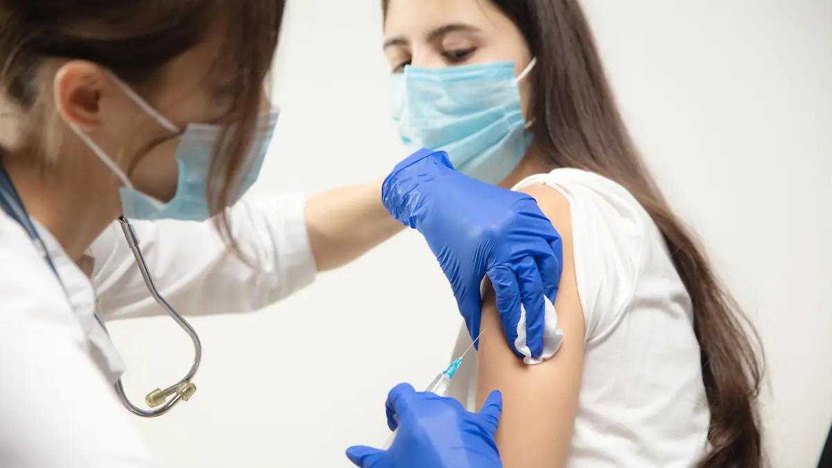 Protect. Close up doctor or nurse giving vaccine to patient using the syringe injected. Works in face mask. Protection against coronavirus, COVID-19 pandemic and pneumonia. Healthcare, medicine.