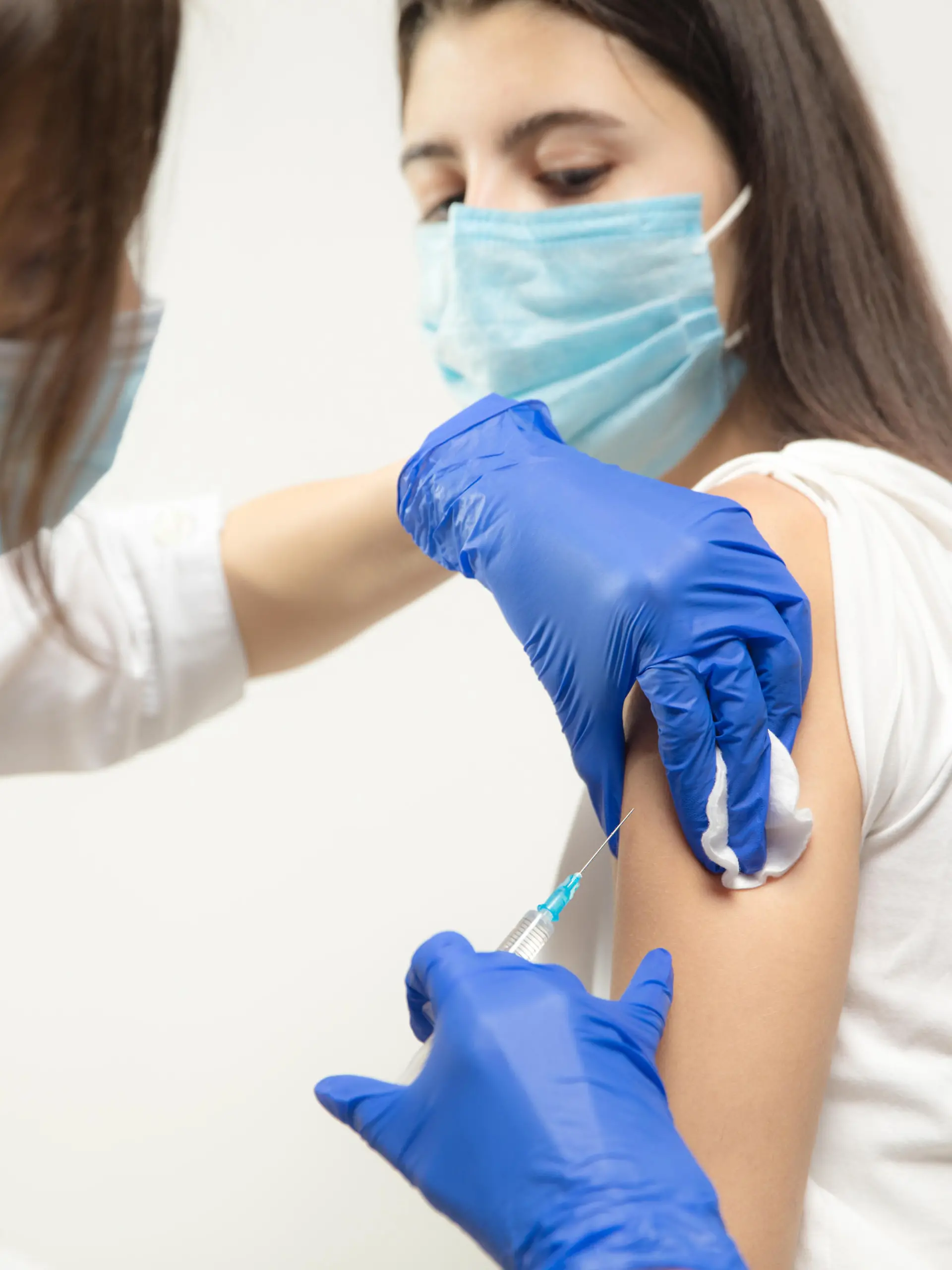 Protect. Close up doctor or nurse giving vaccine to patient using the syringe injected. Works in face mask. Protection against coronavirus, COVID-19 pandemic and pneumonia. Healthcare, medicine.